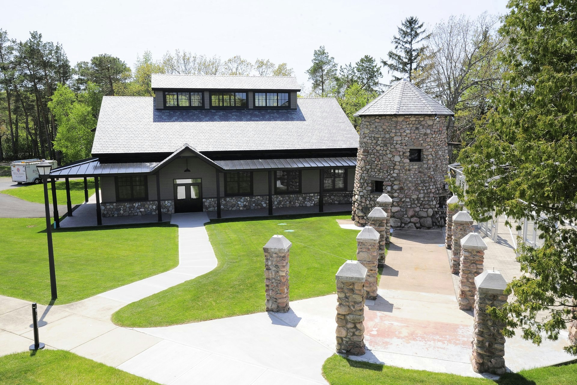 Exterior of the St. Lawerence Distillery; there's a large stone circular structure to the right and a row of smaller stone structures leading to it; unusual distilleries 