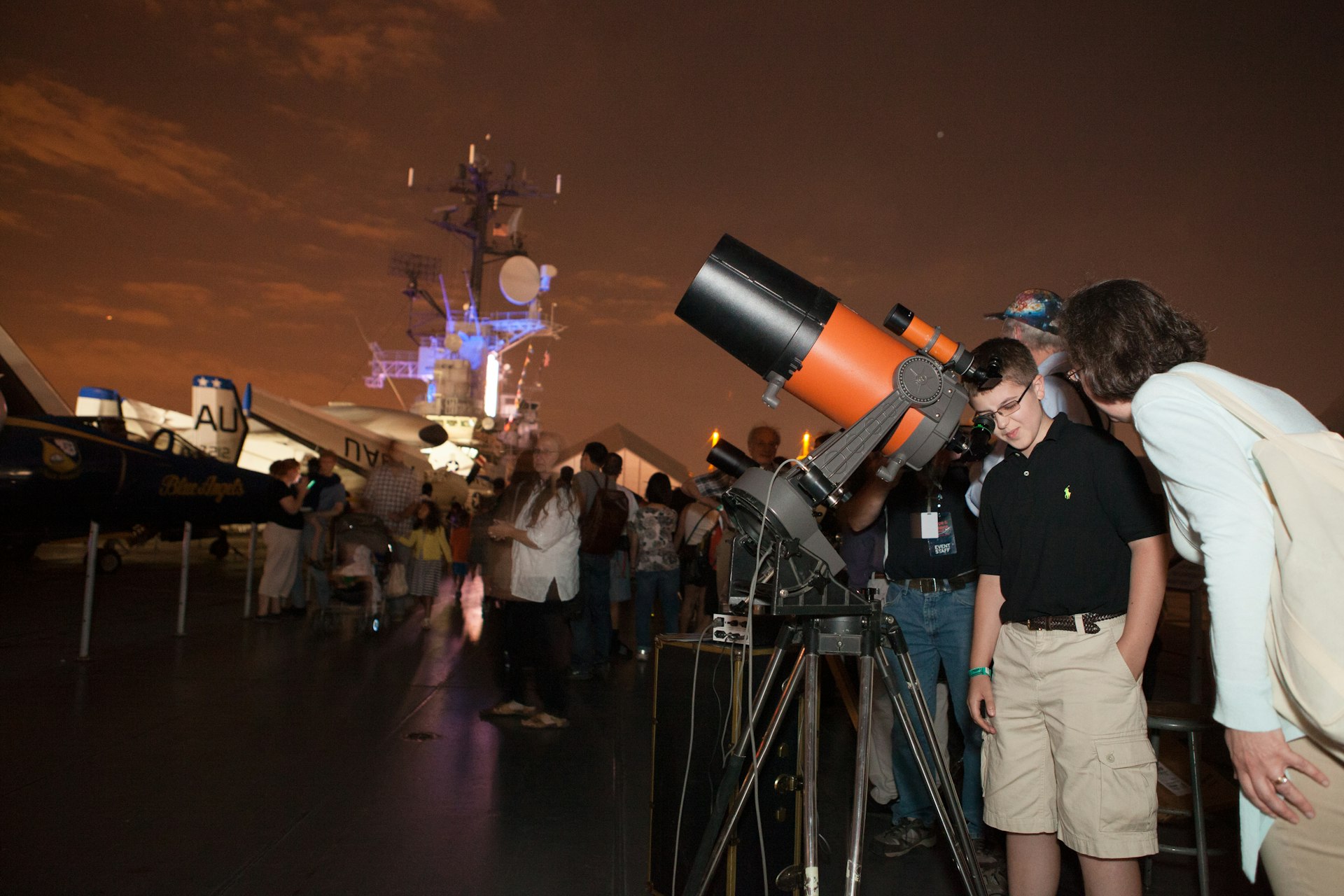 A group of children are shown how to stargaze with the help of telescopes