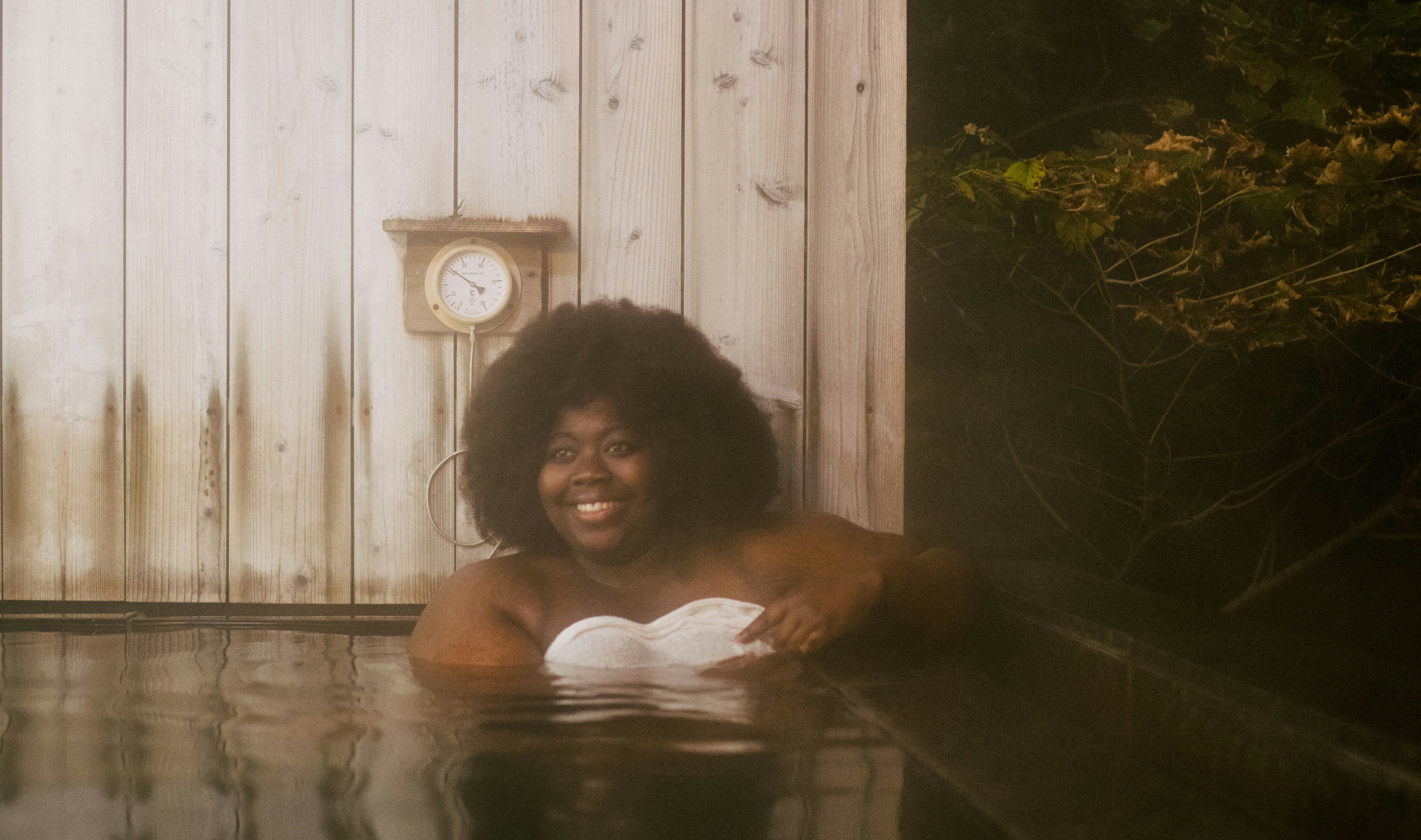 Stephanie Yeboah relaxes in the hot water with a white towel to protect her modesty
