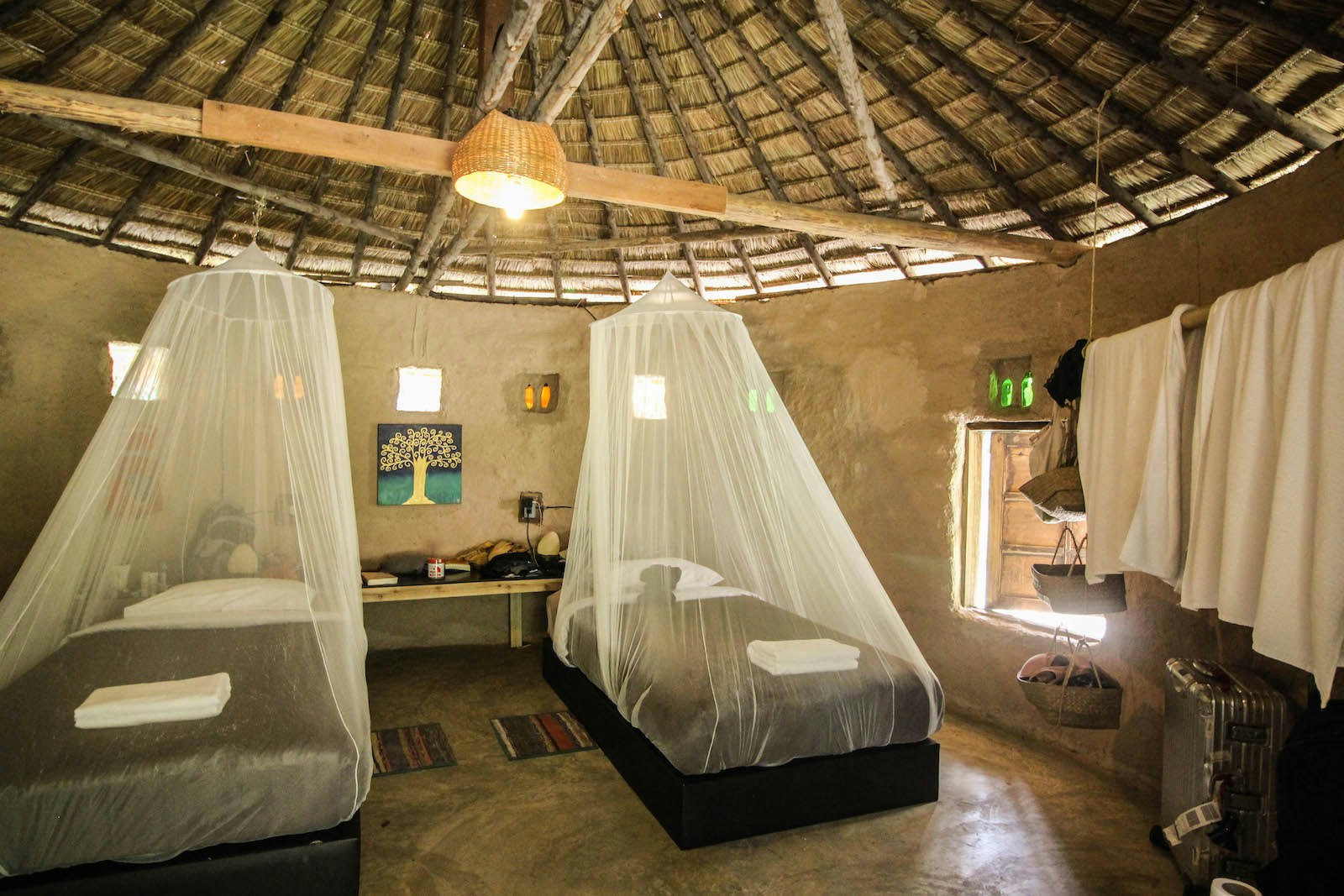 Two twin size beds with fishnet hanging over them inside a circular room