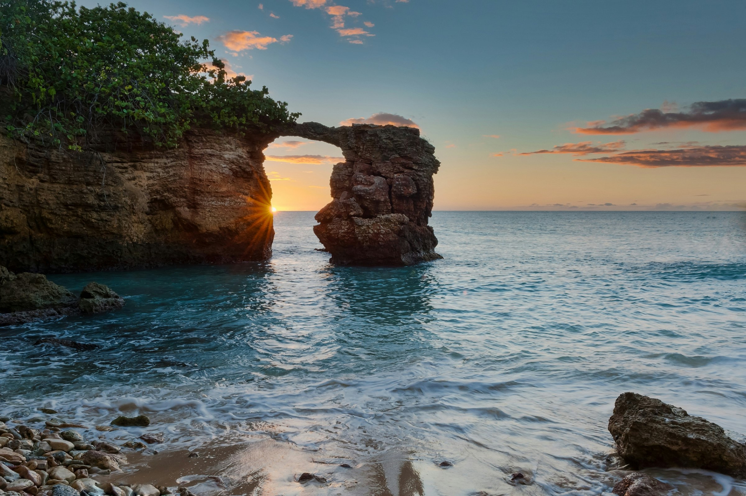 Sunset at the natural bridge formed by rock formation near the Cabo Rojo Lighthouse in Puerto Rico 