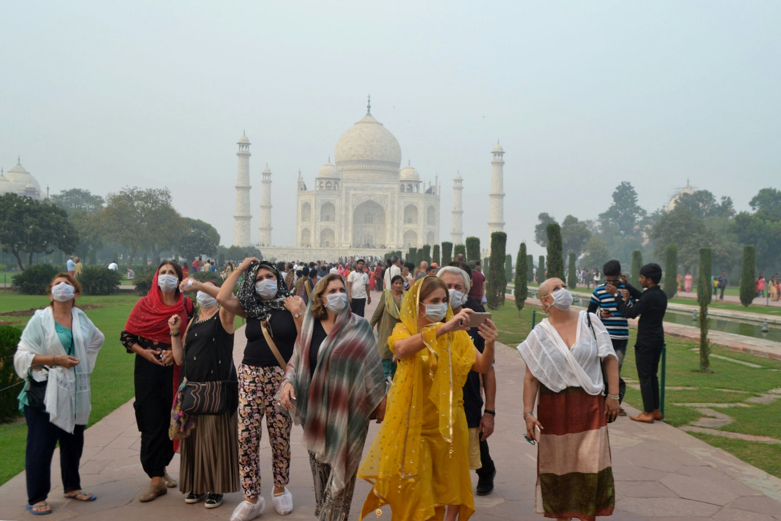 People wearing pollution masks outside the Taj Mahal