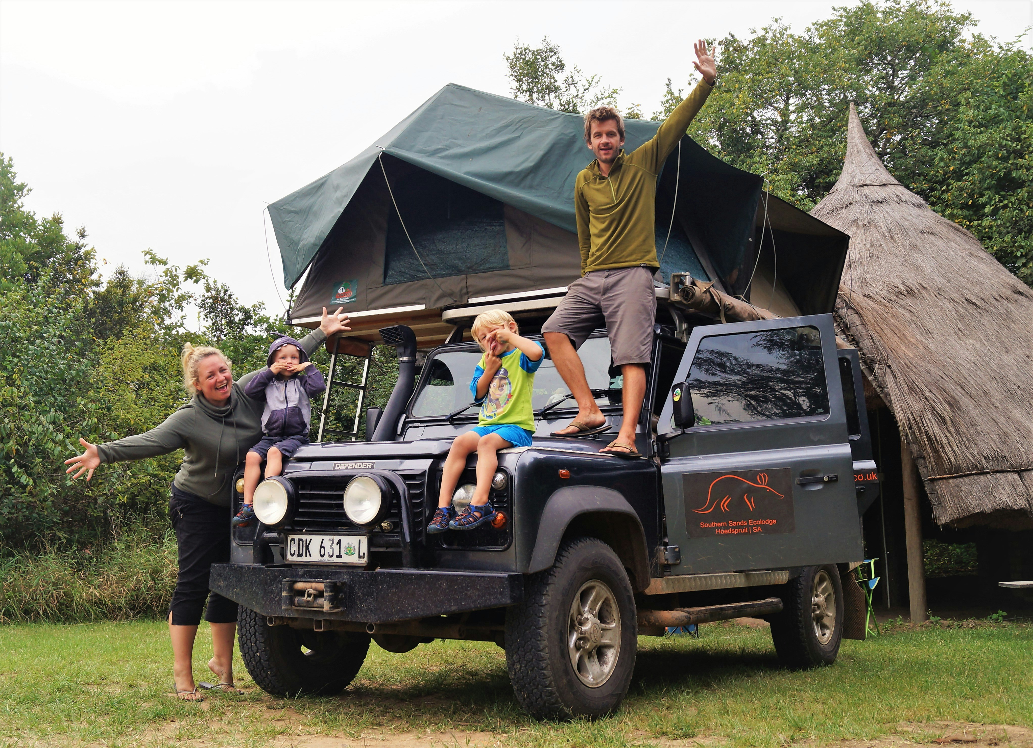 The Lynn family stand in front of their safari jeep.