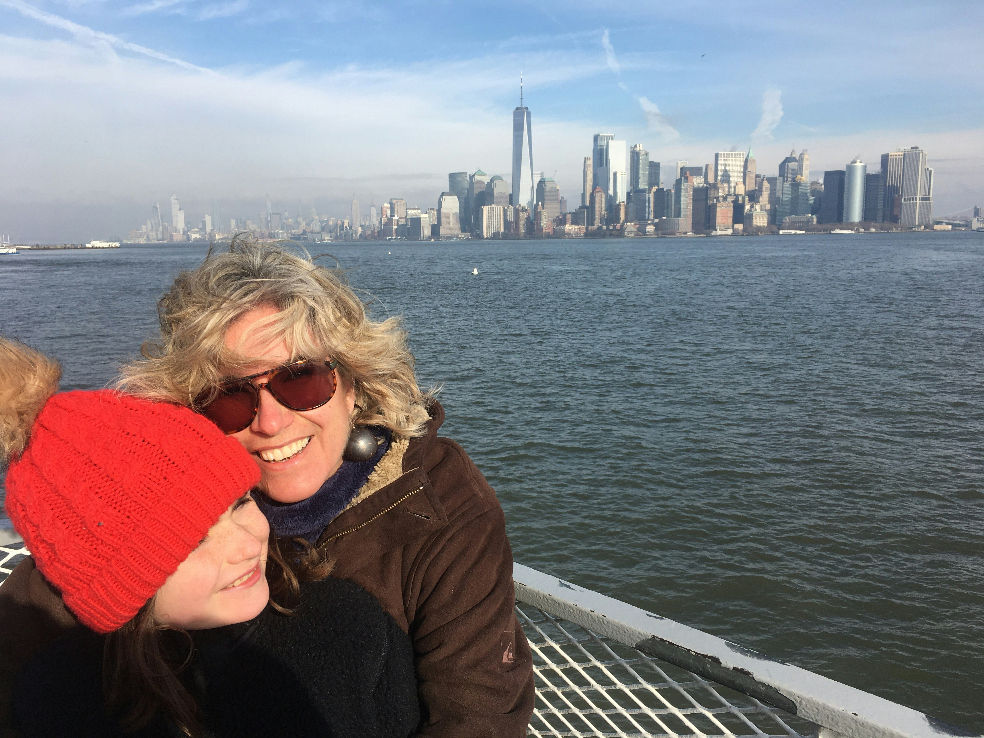 Tasmin Waby with one of her daughters on a boat. The New York City skyline is visible in the background.