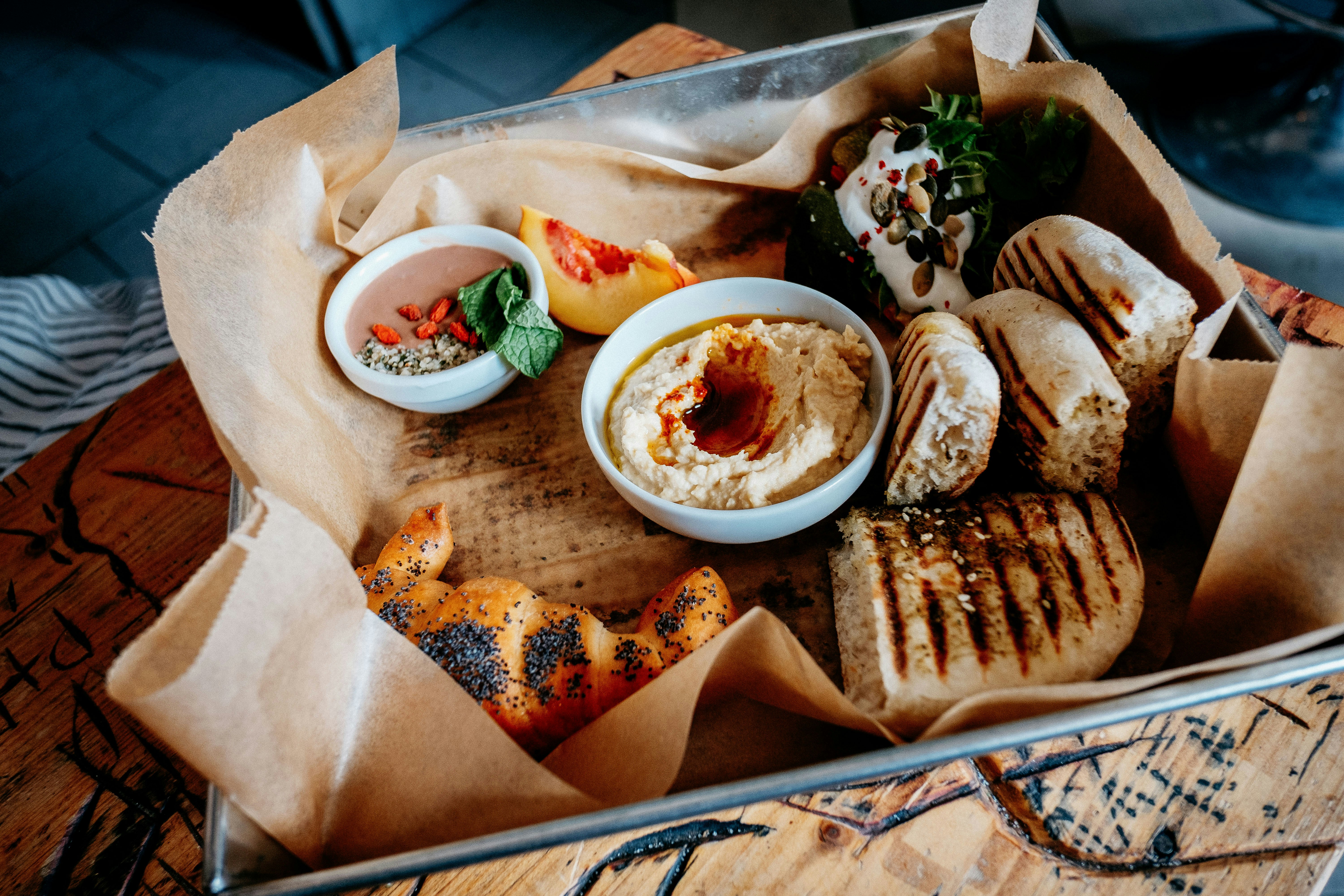 Chargrilled bread, hummus and other dips are arranged in a metal tray lined with baking parchment as part of the Taste of Prague Food Tour.