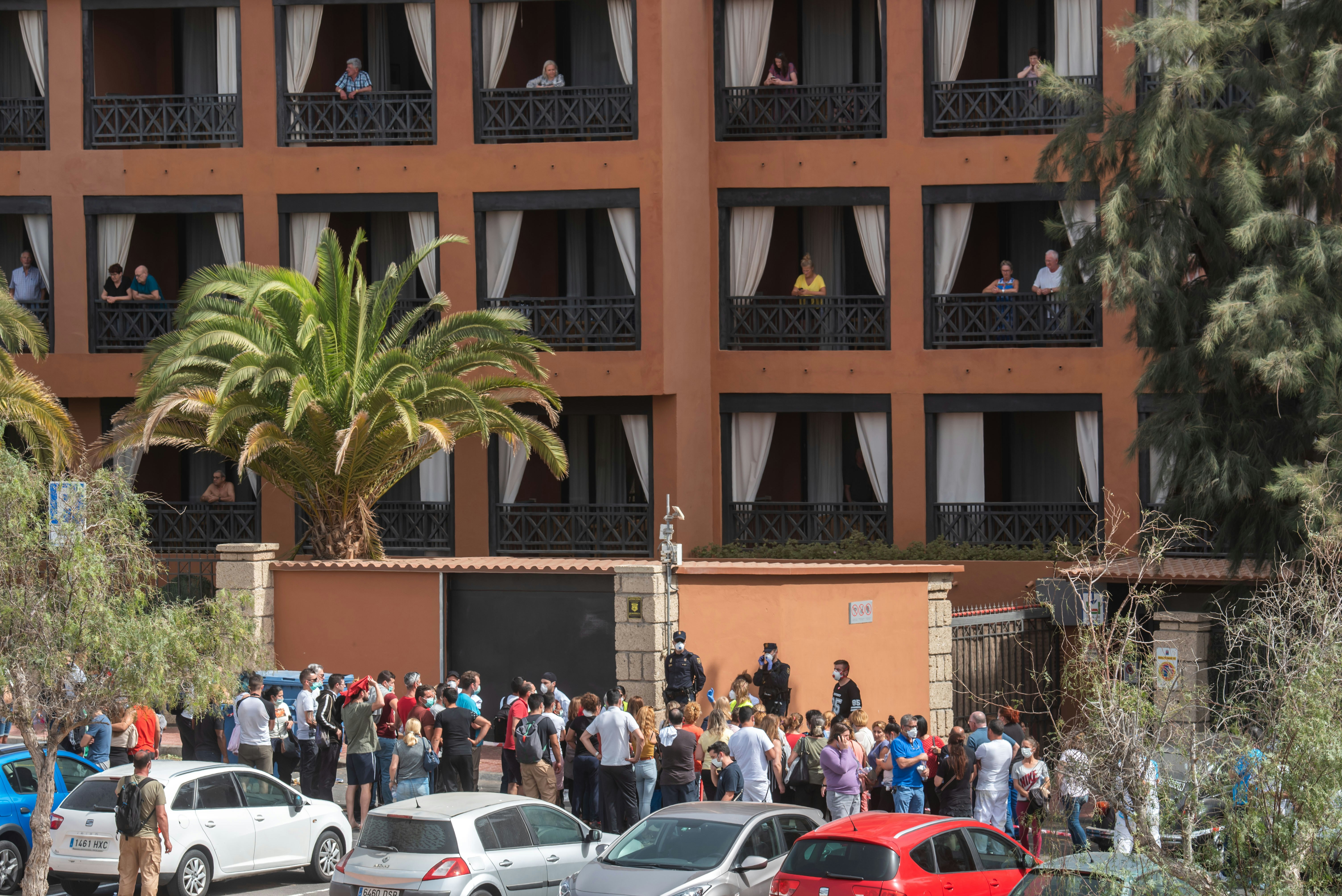 A psychologist talks to a group of workers outside the H10 Costa Adeje Palace Hotel in La Caleta