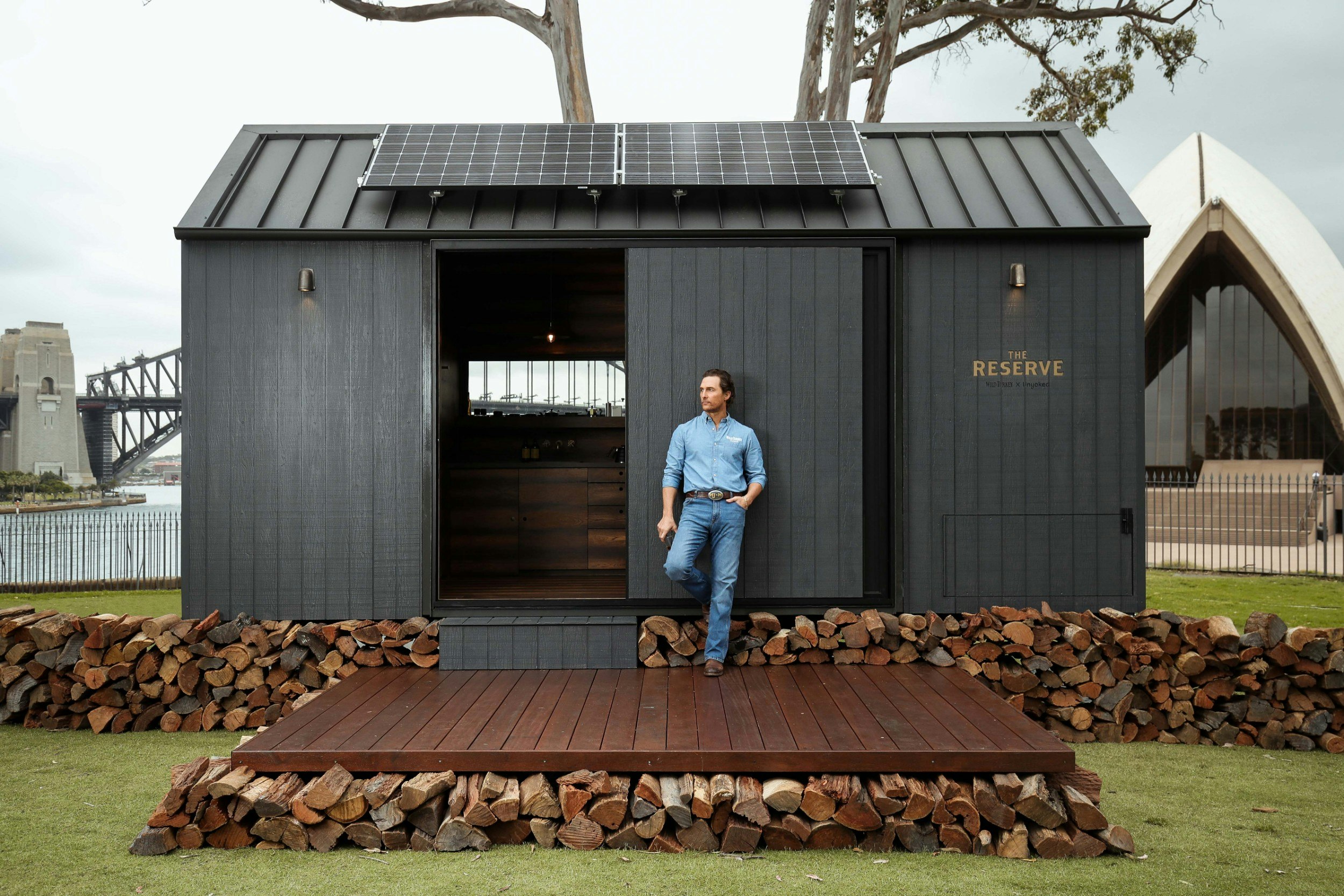 Matthew McConaughey standing at the door of the eco cabin he helped design