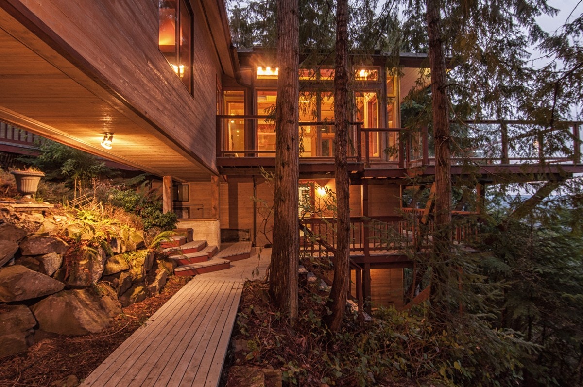 A two-storey wooden house set among trees