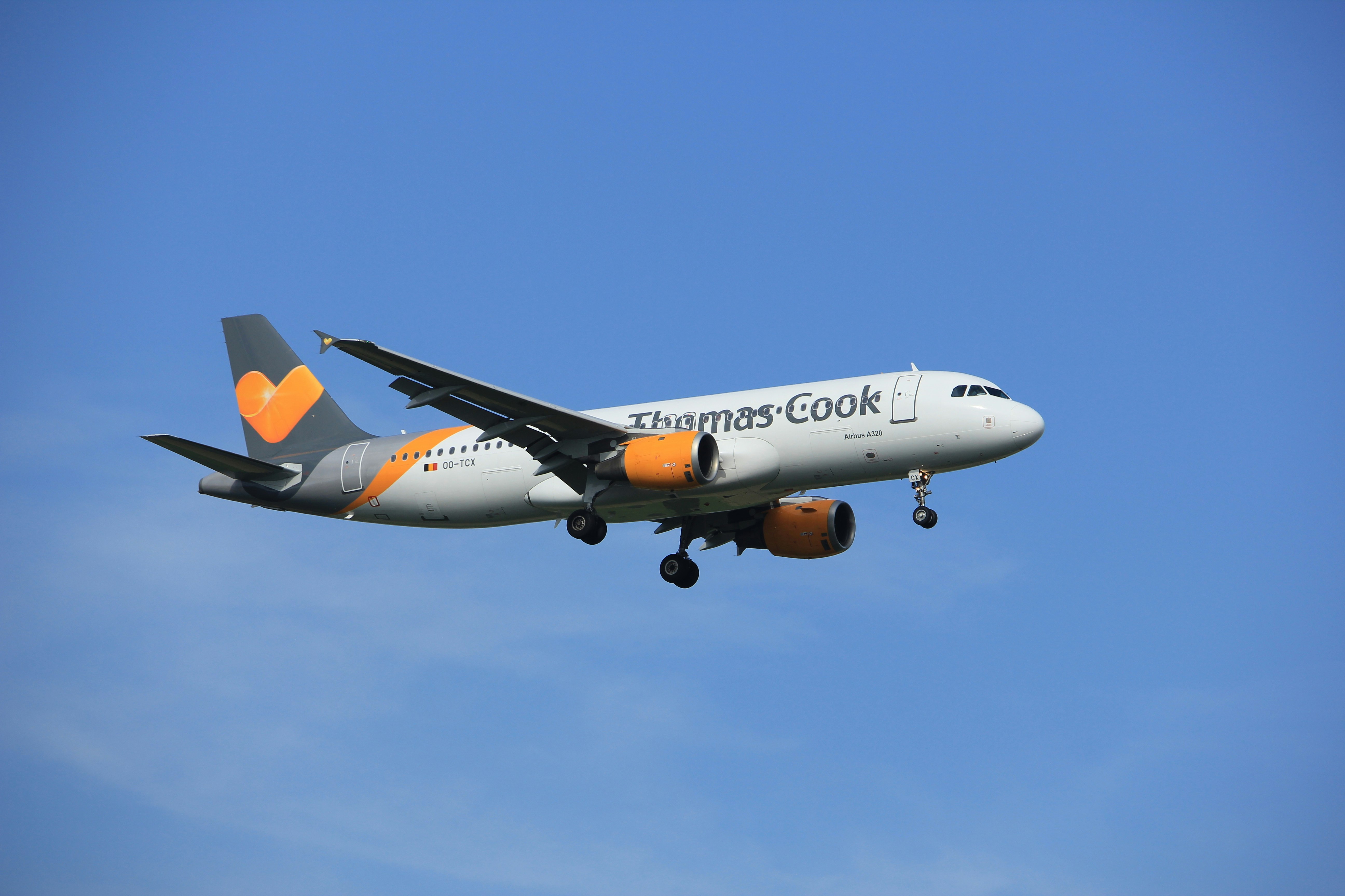 A Thomas Cook plane flies across a blue sky