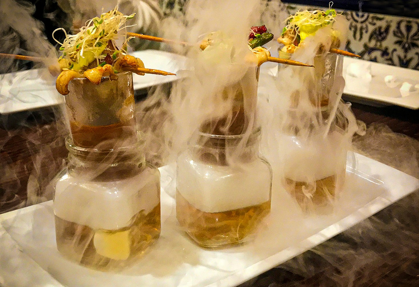 Seafood skewers are balanced on top of steaming glass tumblers, which resemble test tubes, in a display of high gastronomy at a restaurant in Castilla y Leon, Spain