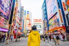 Woman with a yellow jacket walking in the electronic town district of Akihabara, Tokyo. 