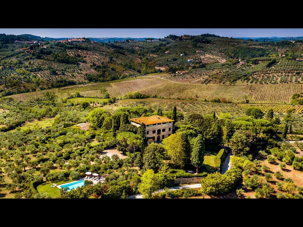 Aerial shot of a mansion in Florence with a pool, in the middle of the countryside