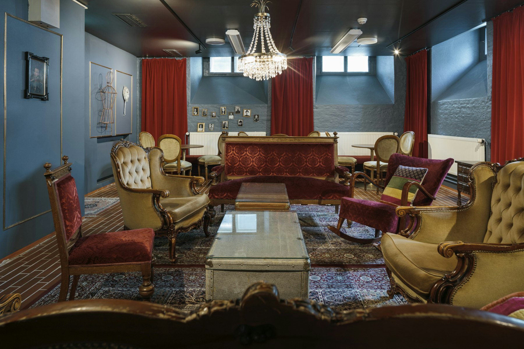 A picture of one of the theatre's sitting rooms with sofas, armchairs and richly decorated carpets and curtains