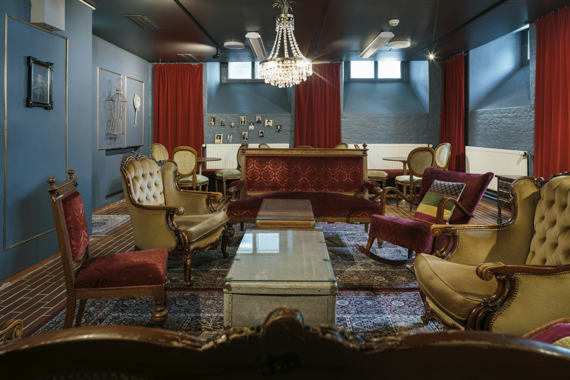 A picture of one of the theatre's sitting rooms with sofas, armchairs and richly decorated carpets and curtains