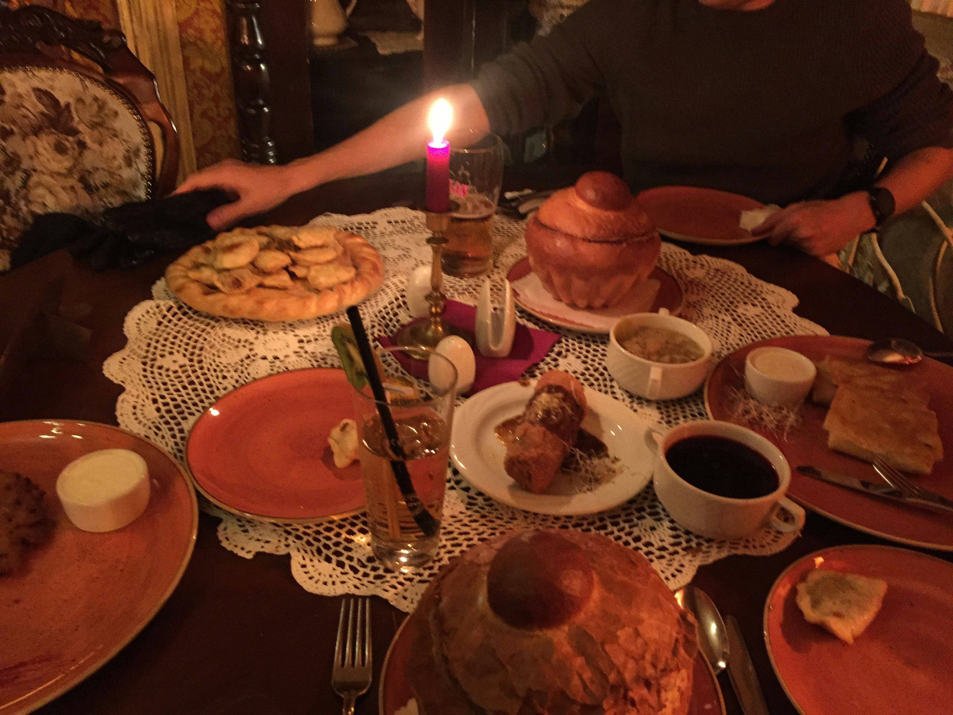 Several plates in a dimly lit room, included bread bowls and pancakes