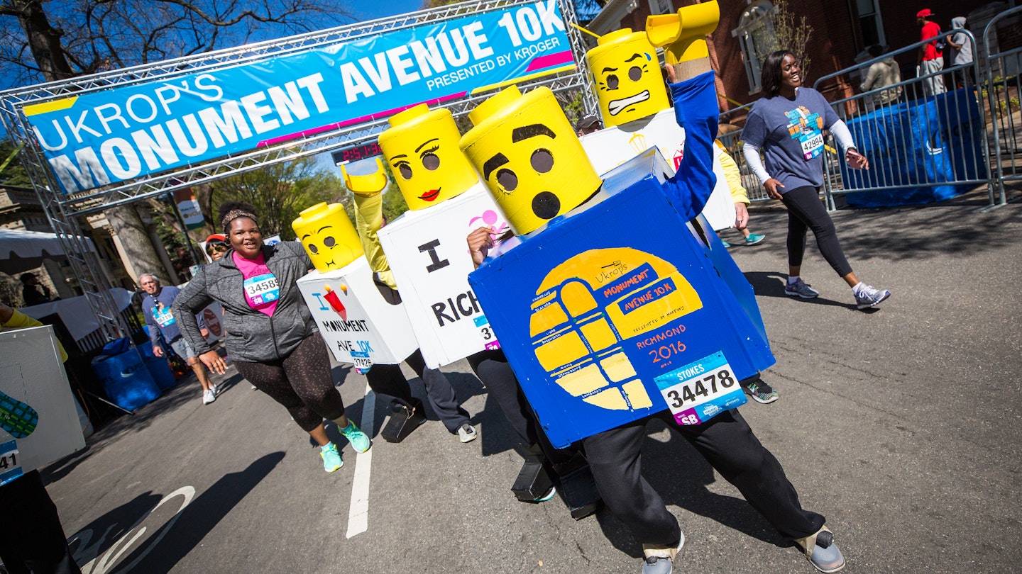 A group of people dressed as legos cross the finish line of a 10K race