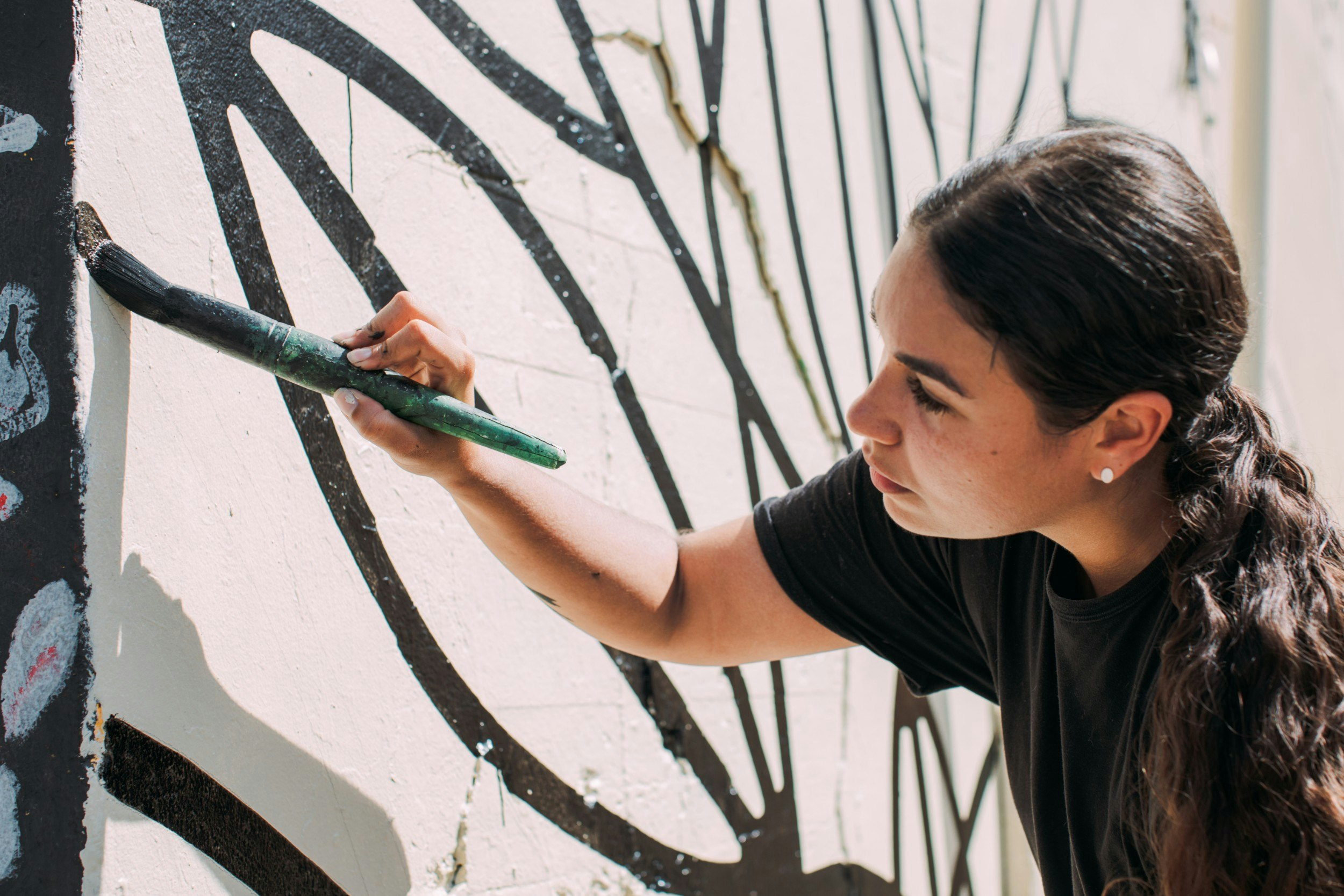 Artist Vero Rivera painting a street mural
