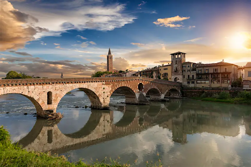 Verona.jpg a stone bridge over a river leading to a medieval town