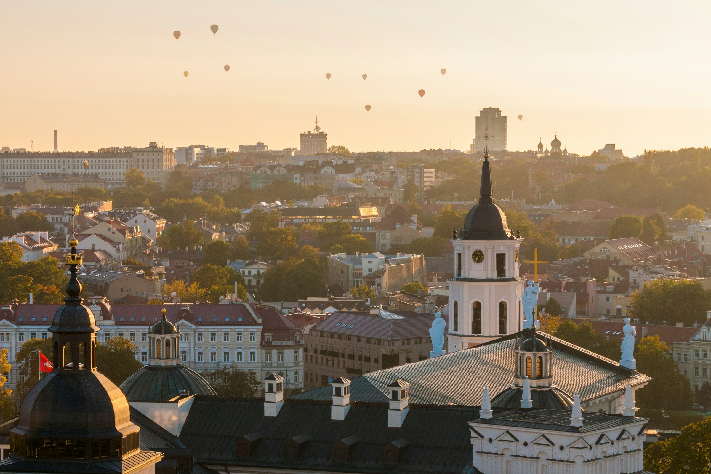 Hot-air balloons flying over Vilnius at sunset. 