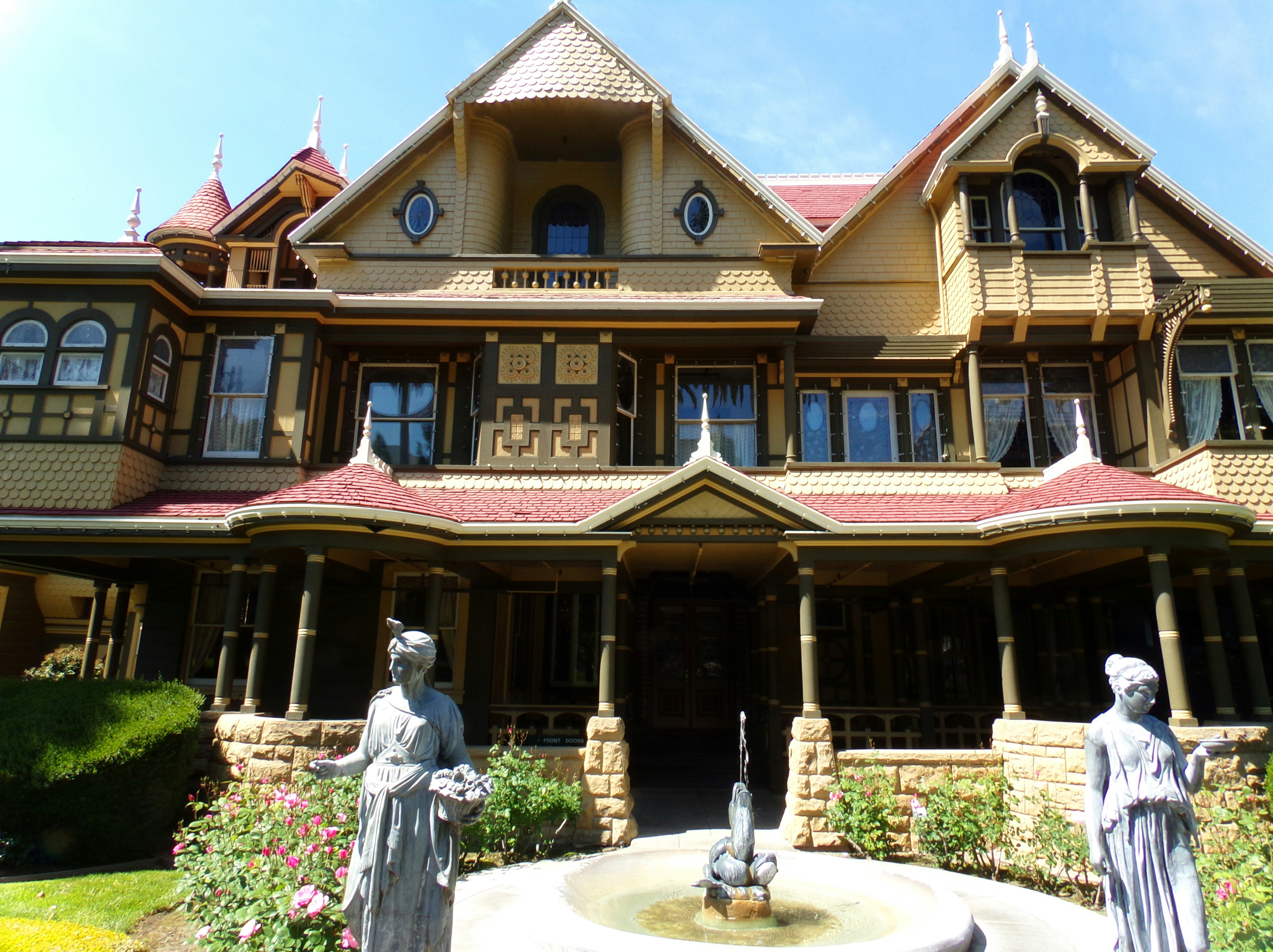 A pair of statues and a fountain sit outside the ornate Winchester Mystery House; US haunted places