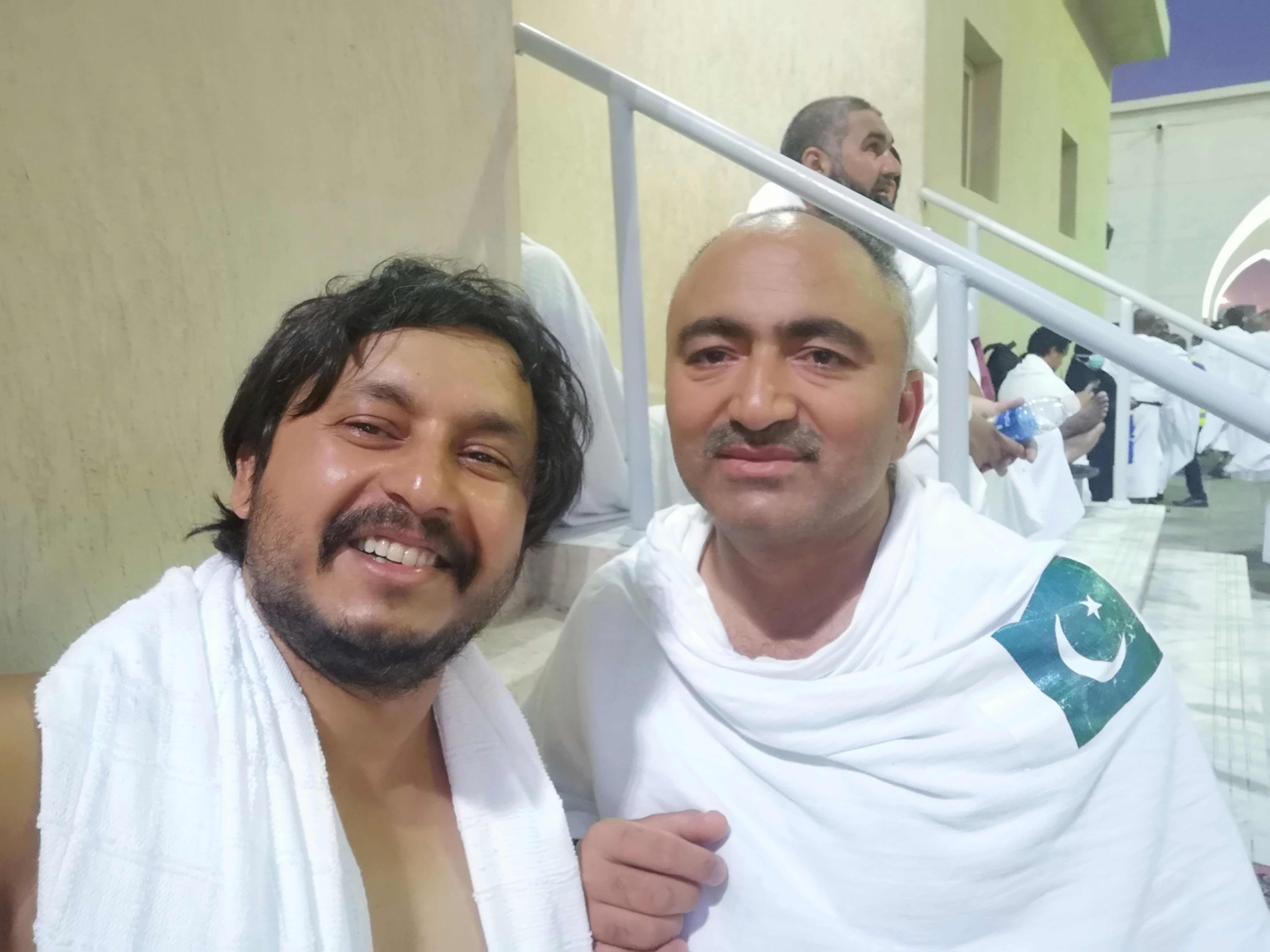 Tharik and Abid look to the camera in white robes