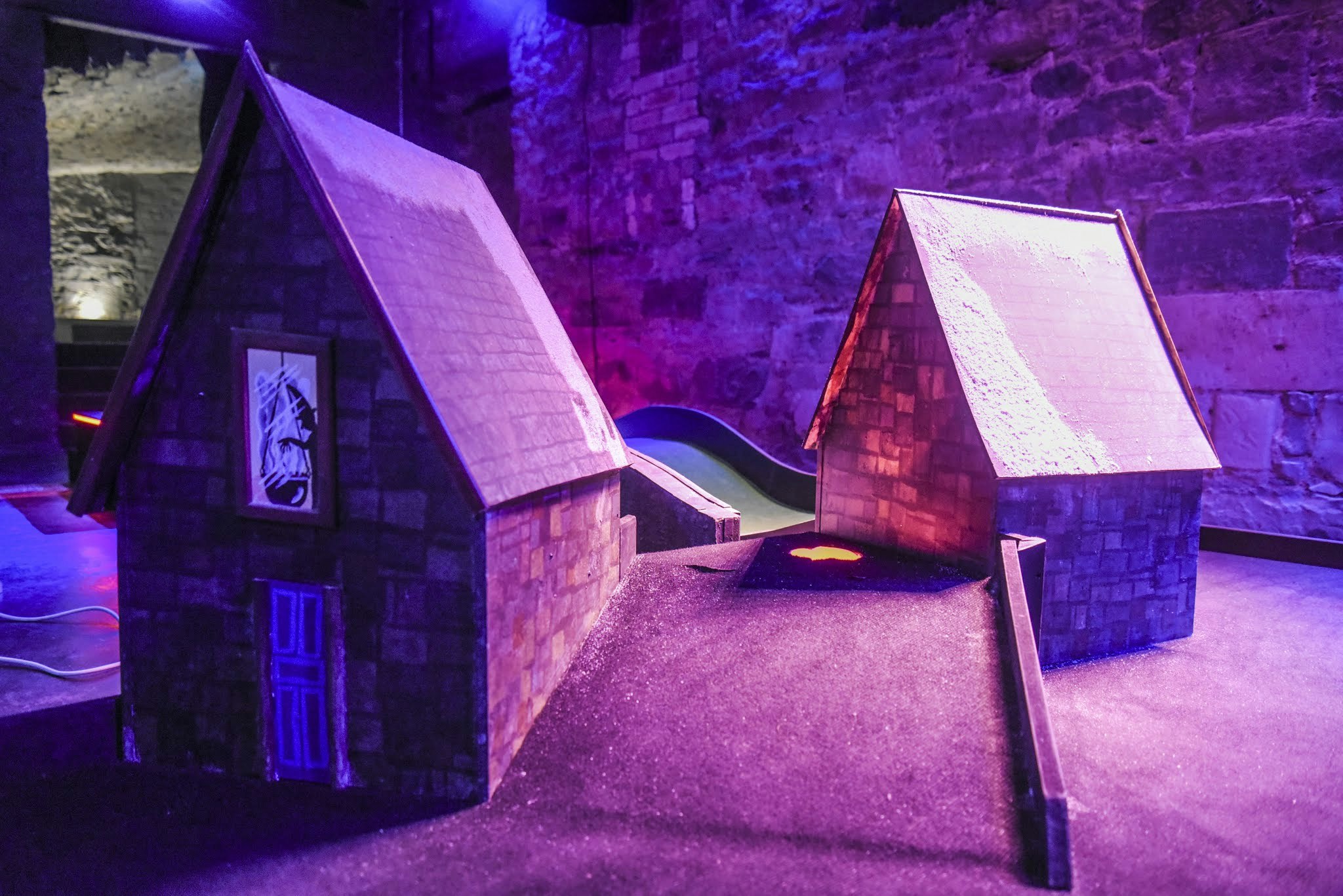 Two small model houses are part of the indoor mini golf course at Wizard Golf, in Edinburgh, Scotland. 