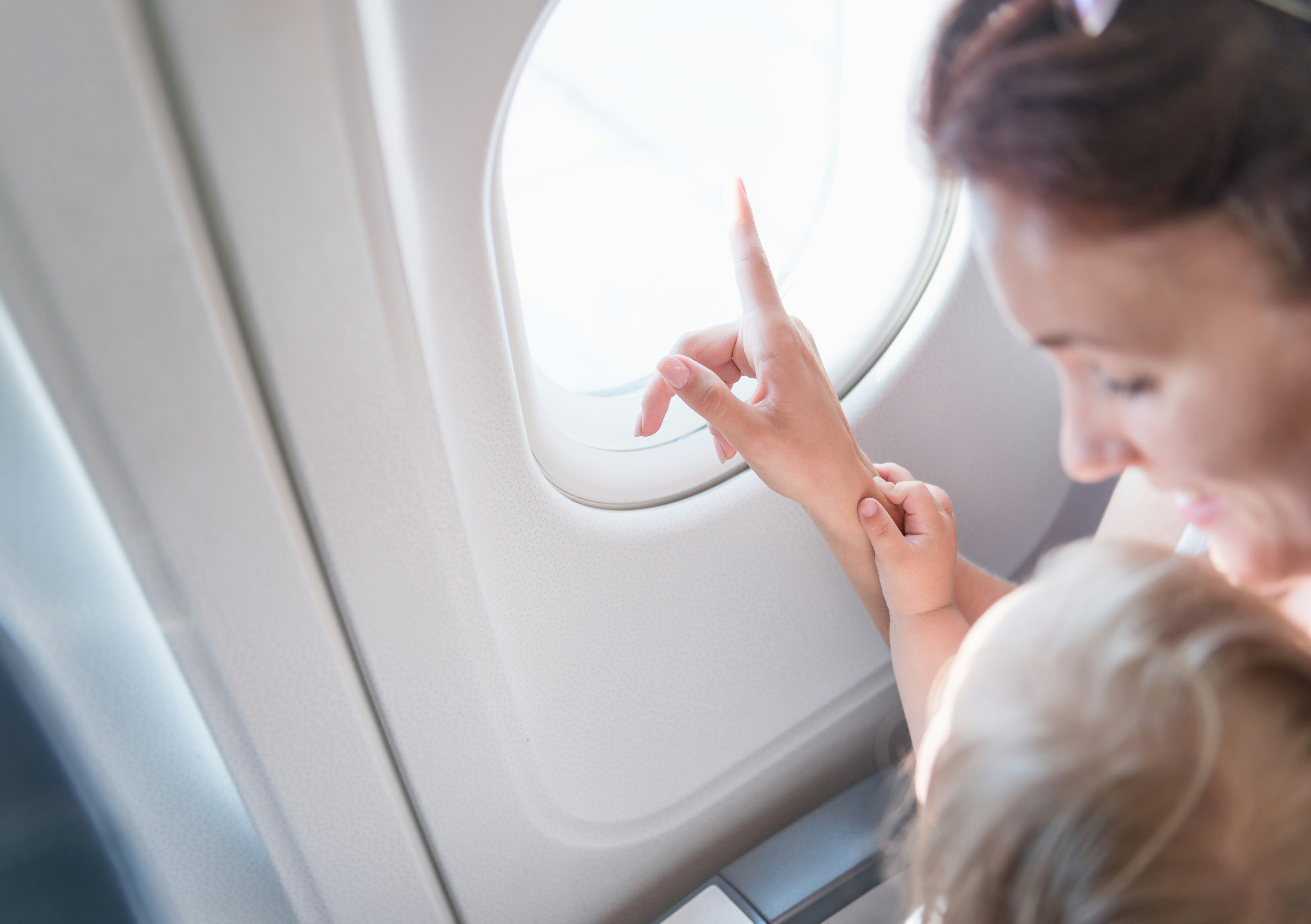 Woman and child pointing out of a plane window