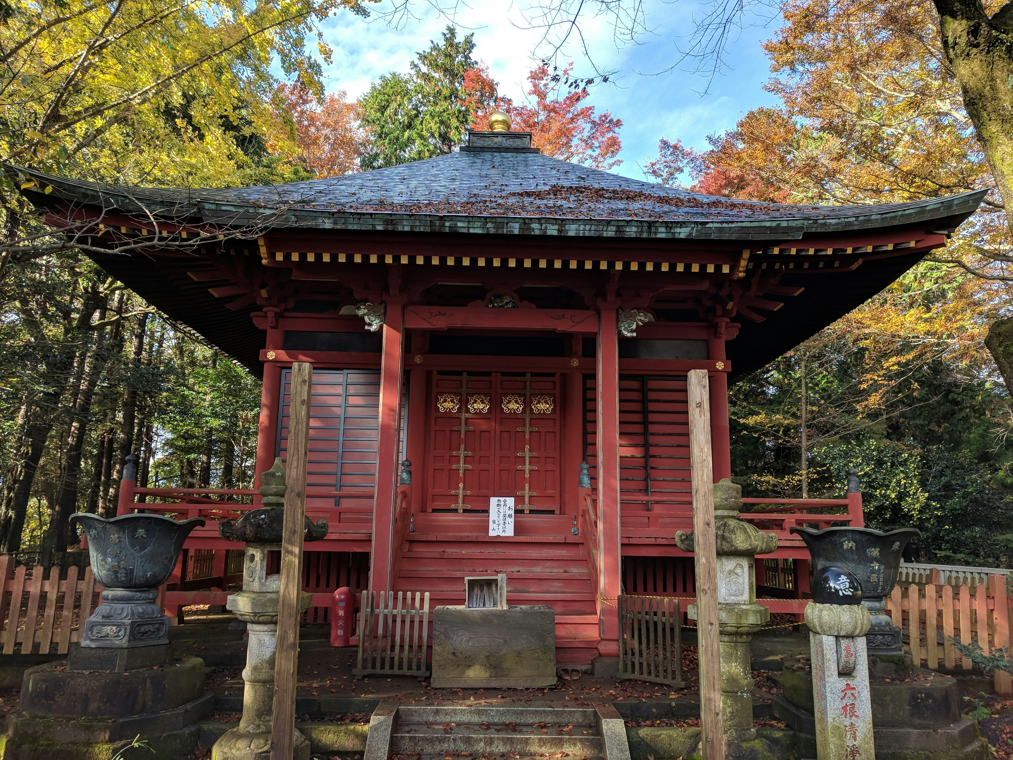 Okunoin Fudo-do Hall, part of the Yakouin Shinto temple complex, on Mt Takao. The temple is a small, square building with red walls and a traditional Japanese-style sloping roof.