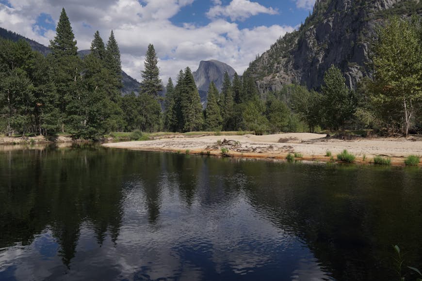Half Dome ses genom några träd;  hur man fotograferar Yosemite som Ansel Adams