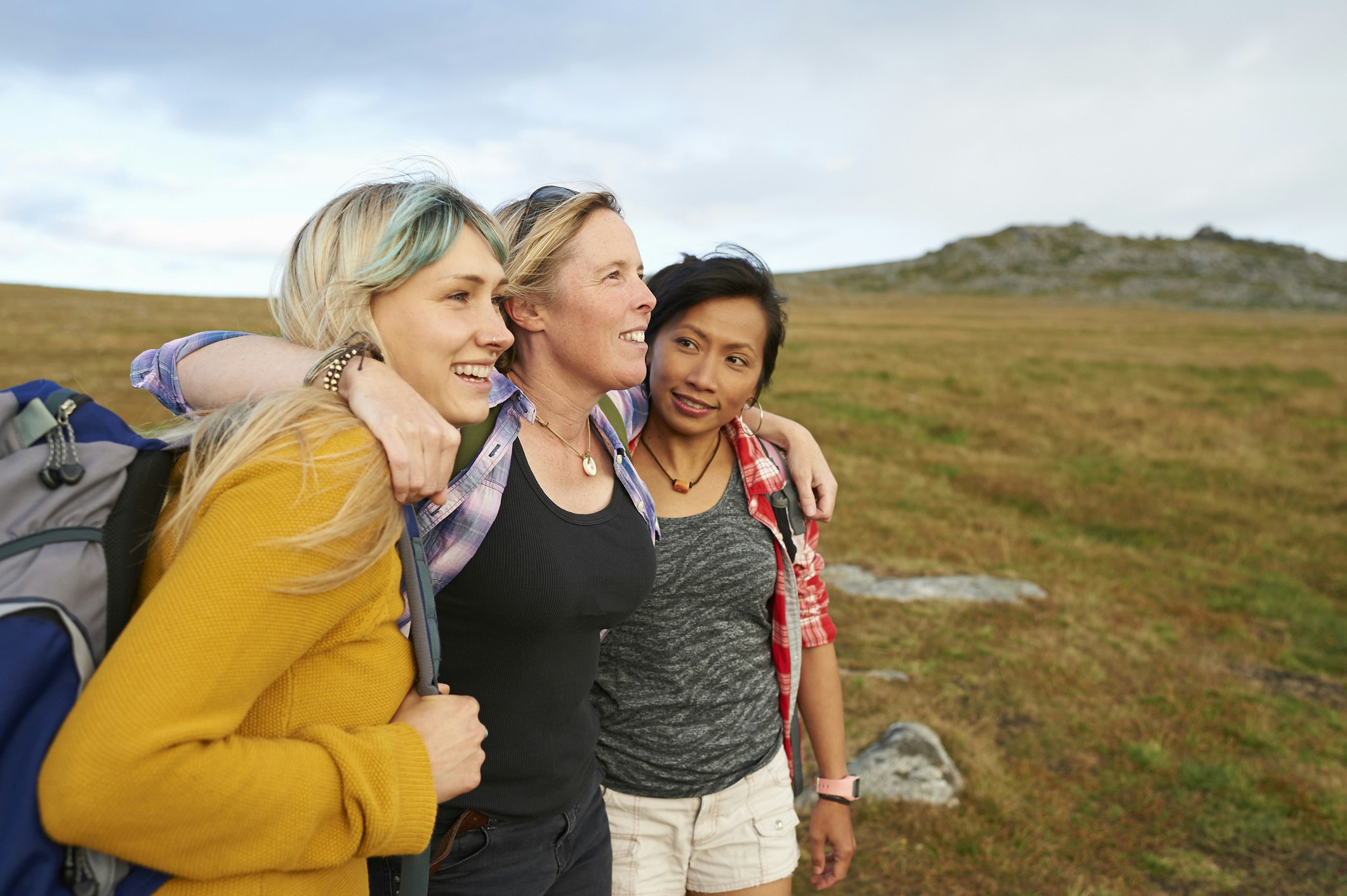 A group of women hugging while out on the road