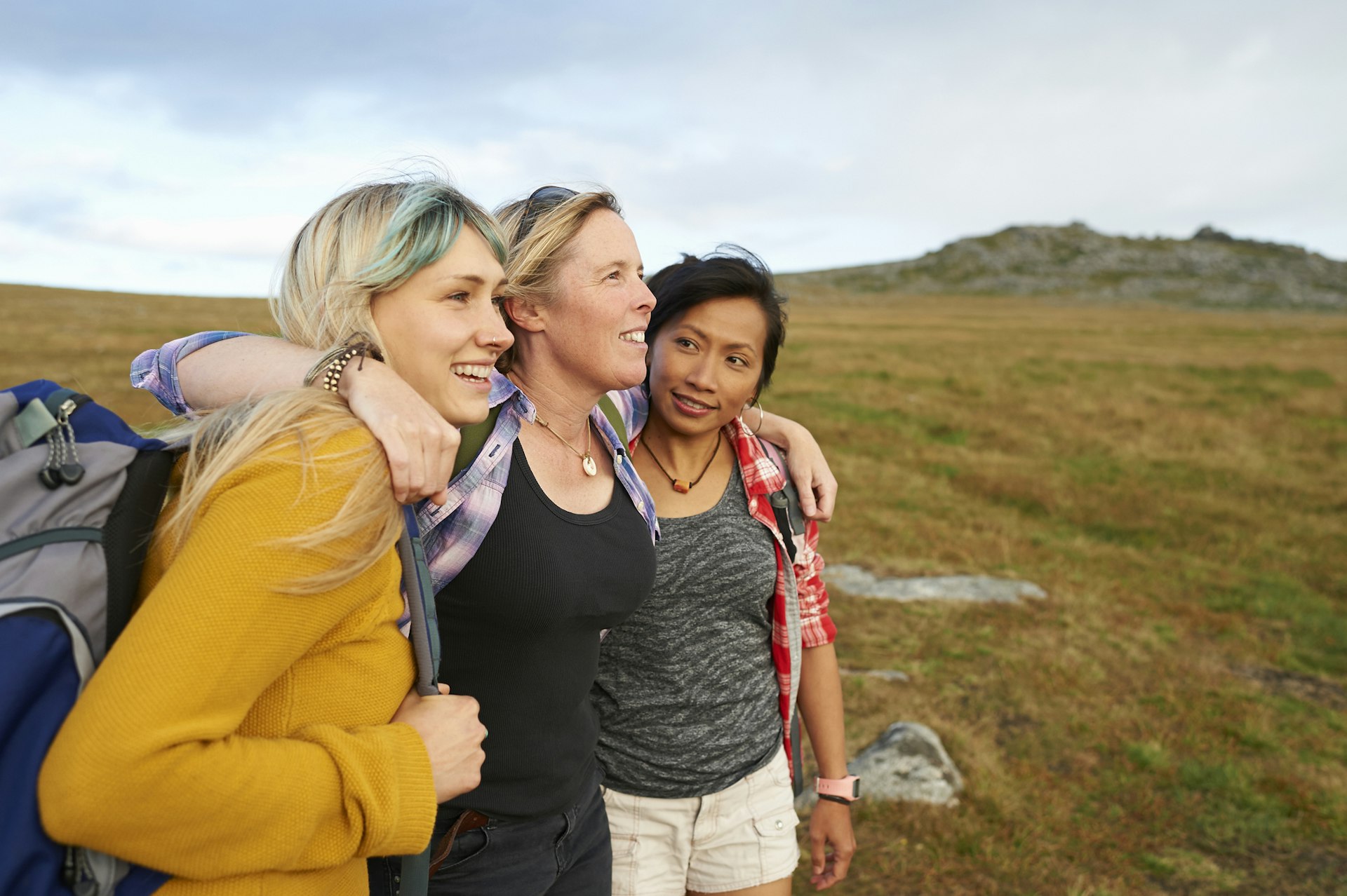 A group of women hugging while out on the road
