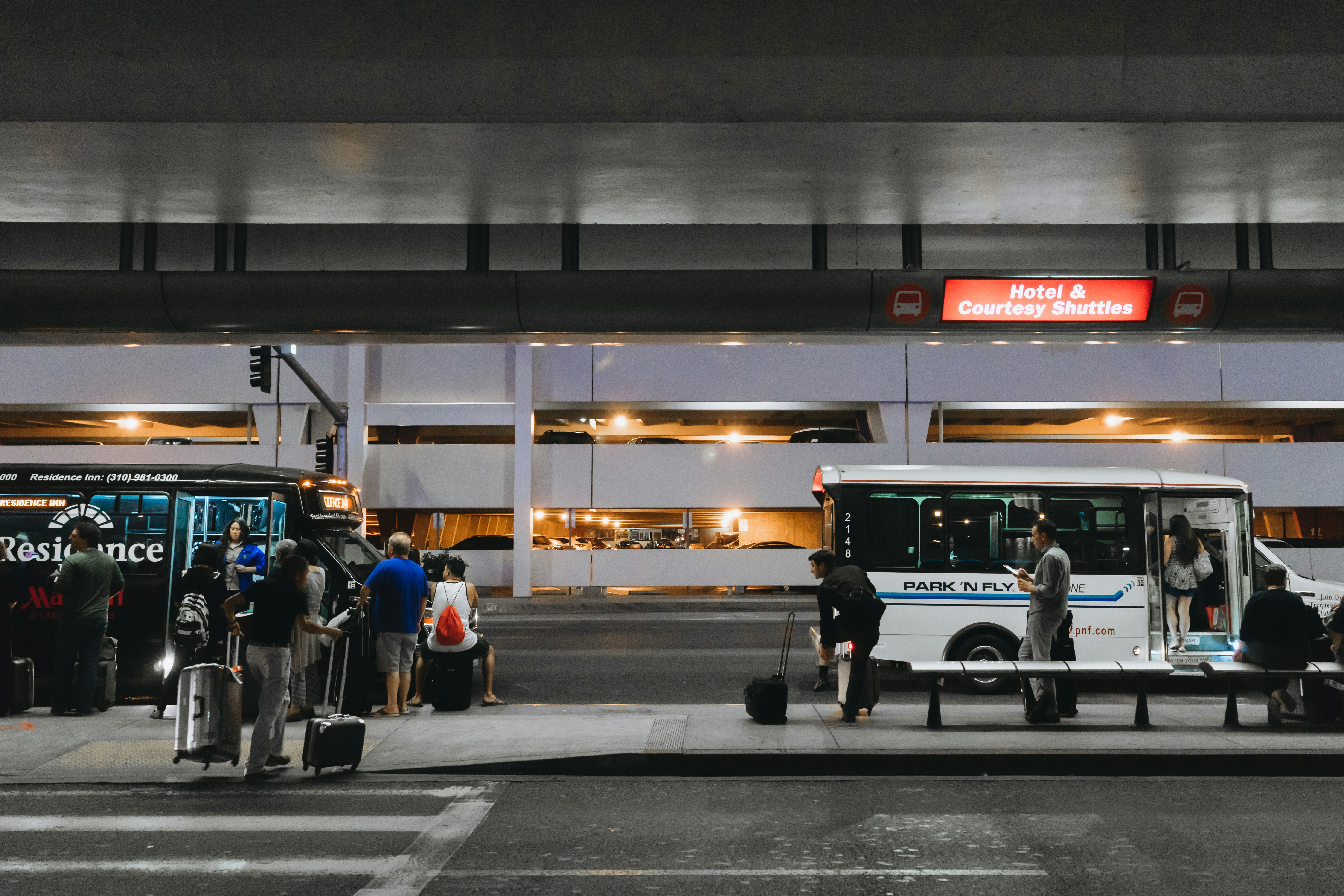 Arrivals queue up at bus stops to catch courtesy shuttle buses to airport hotels at night.