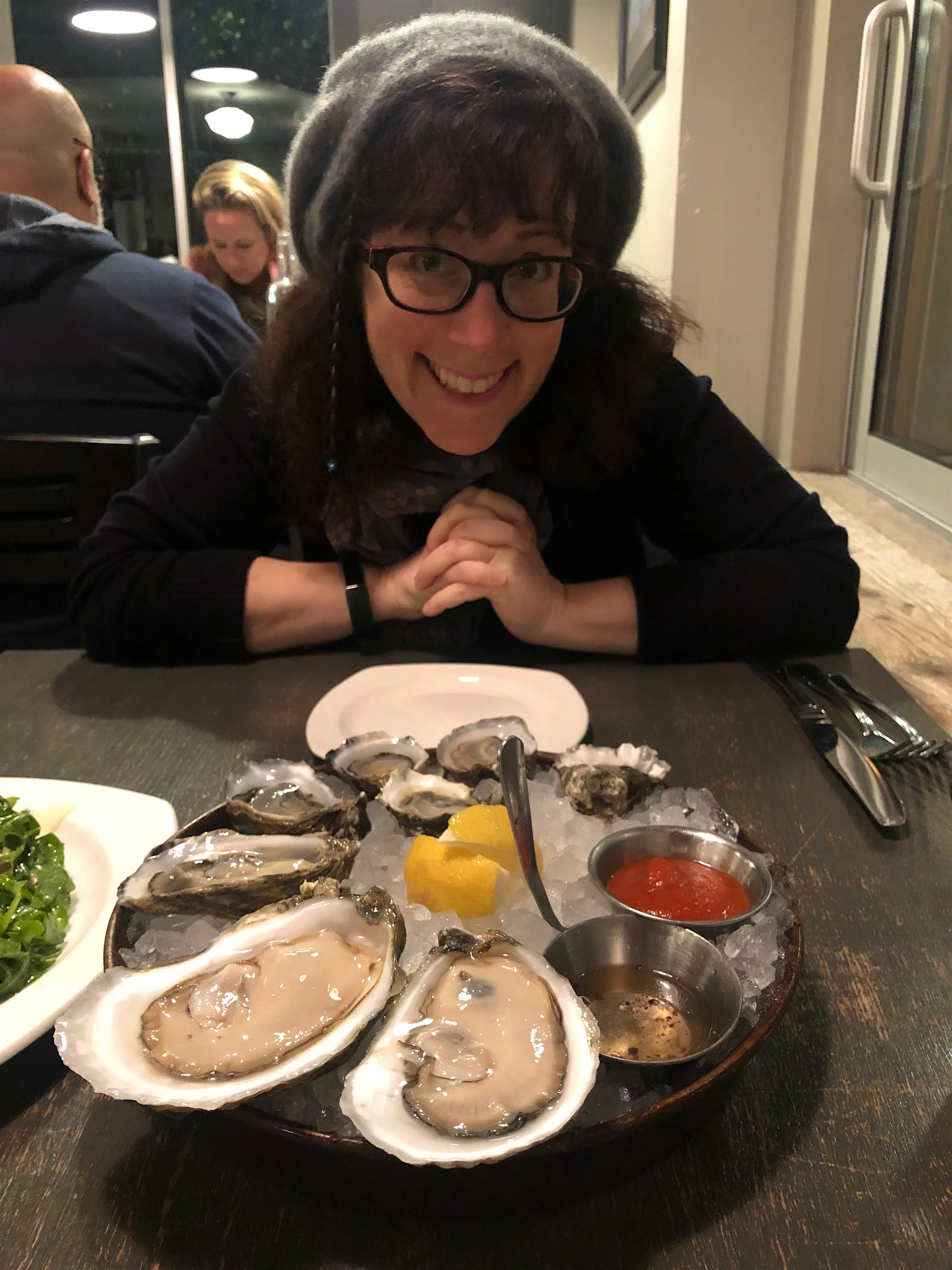 alex leviton.jpeg A woman smiling next to a plate of raw oysters