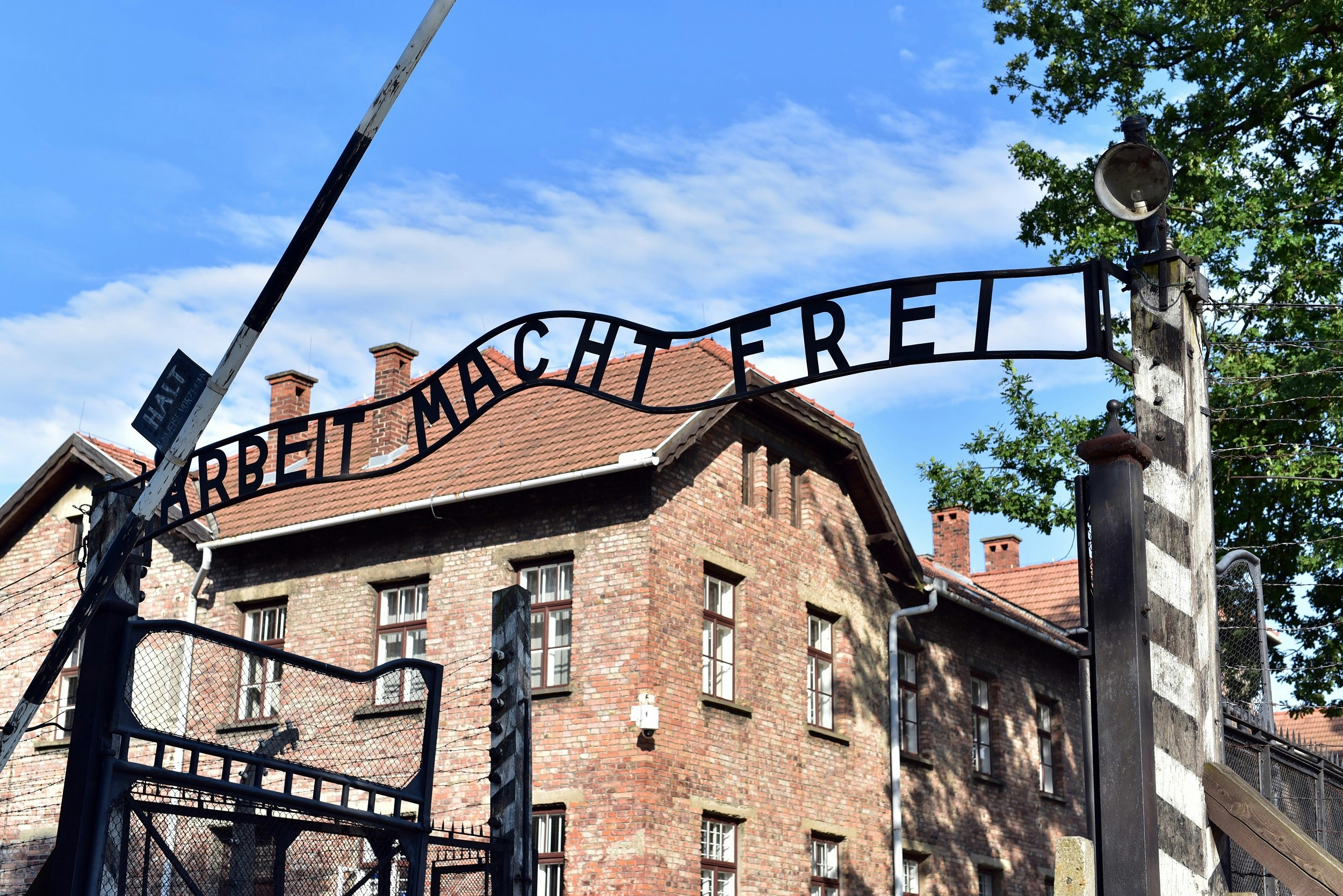 A gateway with writing in wrought-iron above it saying "Arbeit Macht Frei" which translates to "Work will make you free".