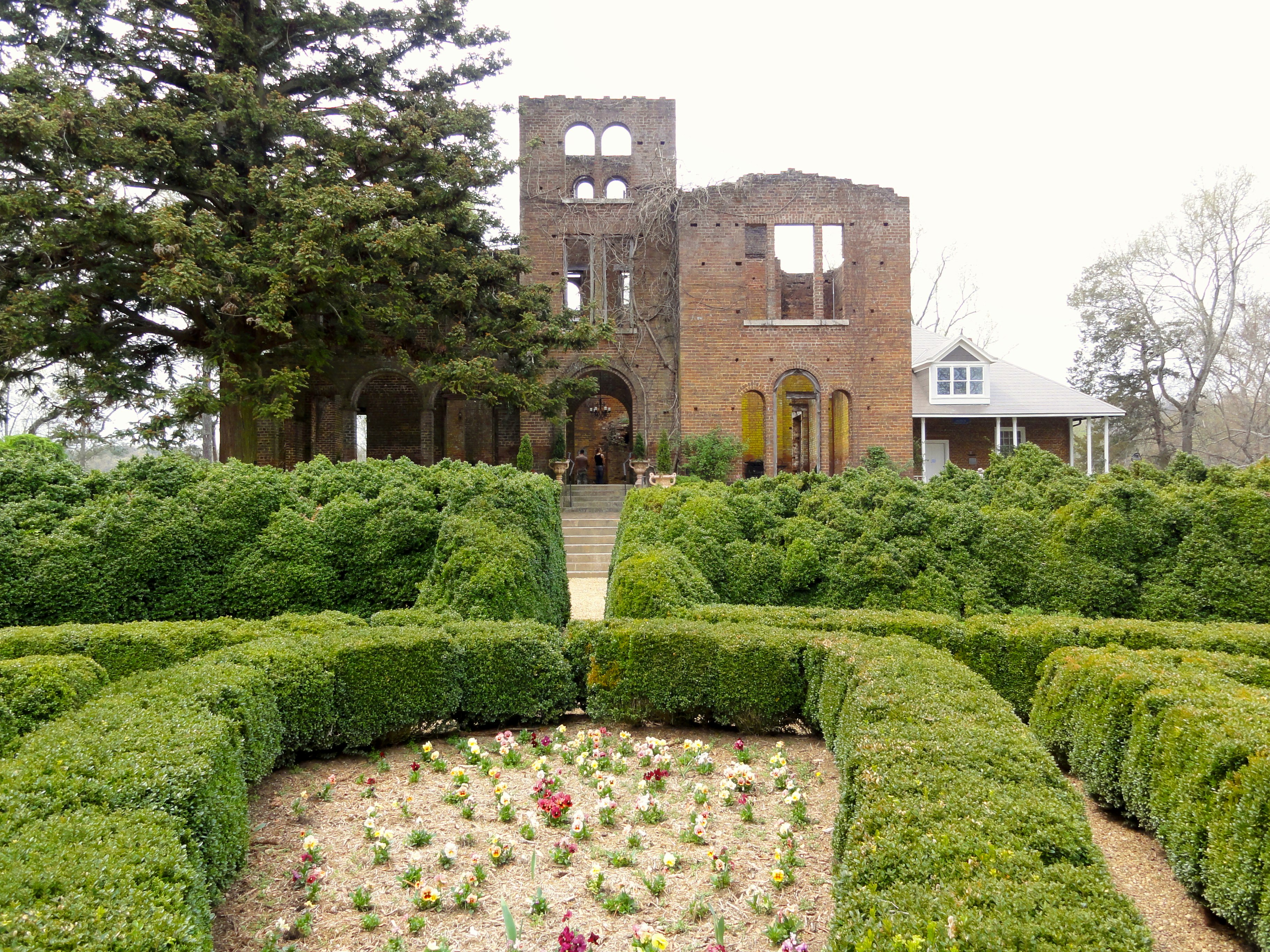 The brick ruins of an ornate Italianate villa overlooks trimmed hedges and flower gardens at this Adairsville agritourism destination