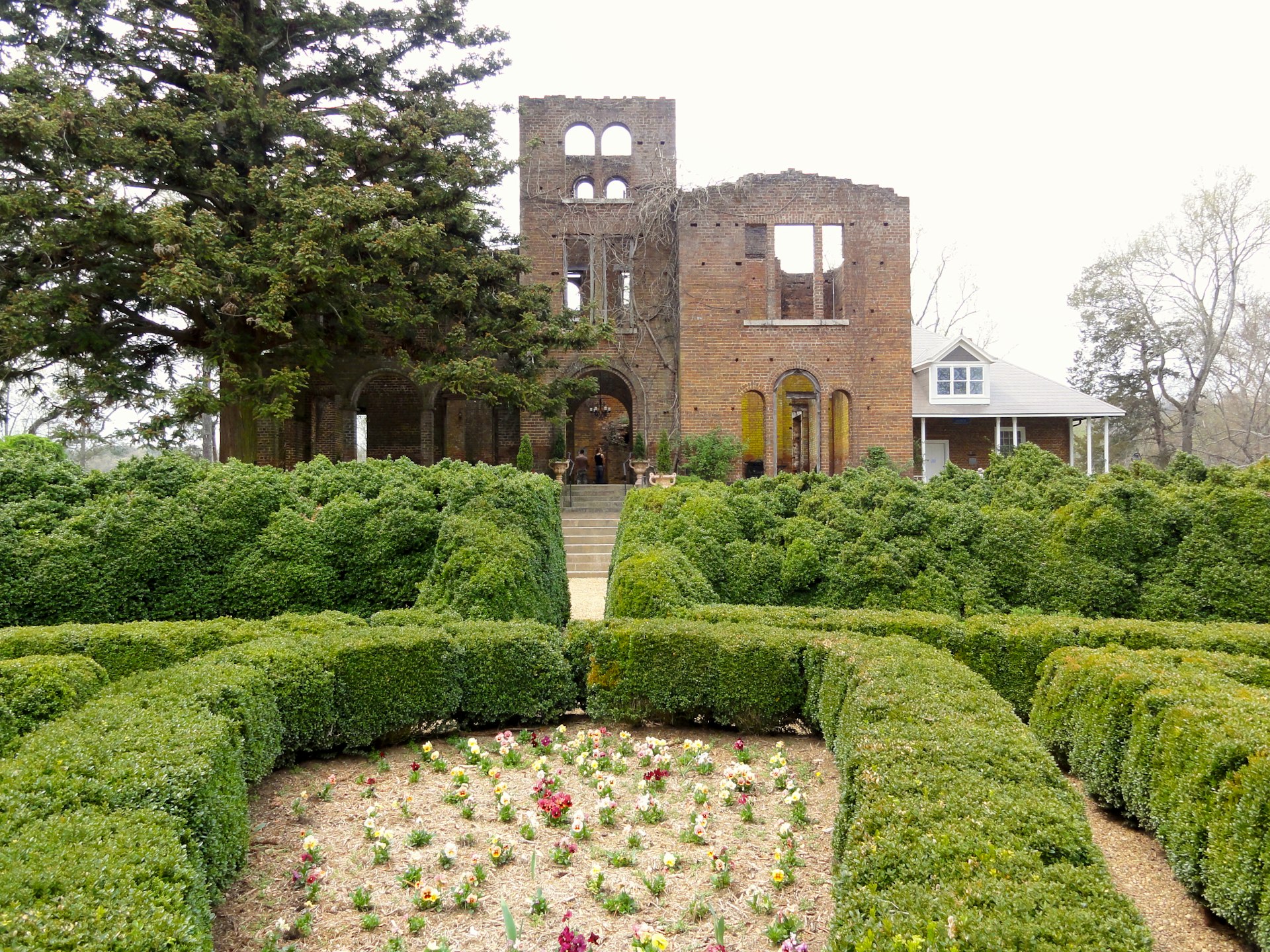 The brick ruins of an ornate Italianate villa overlooks trimmed hedges and flower gardens at this Adairsville agritourism destination