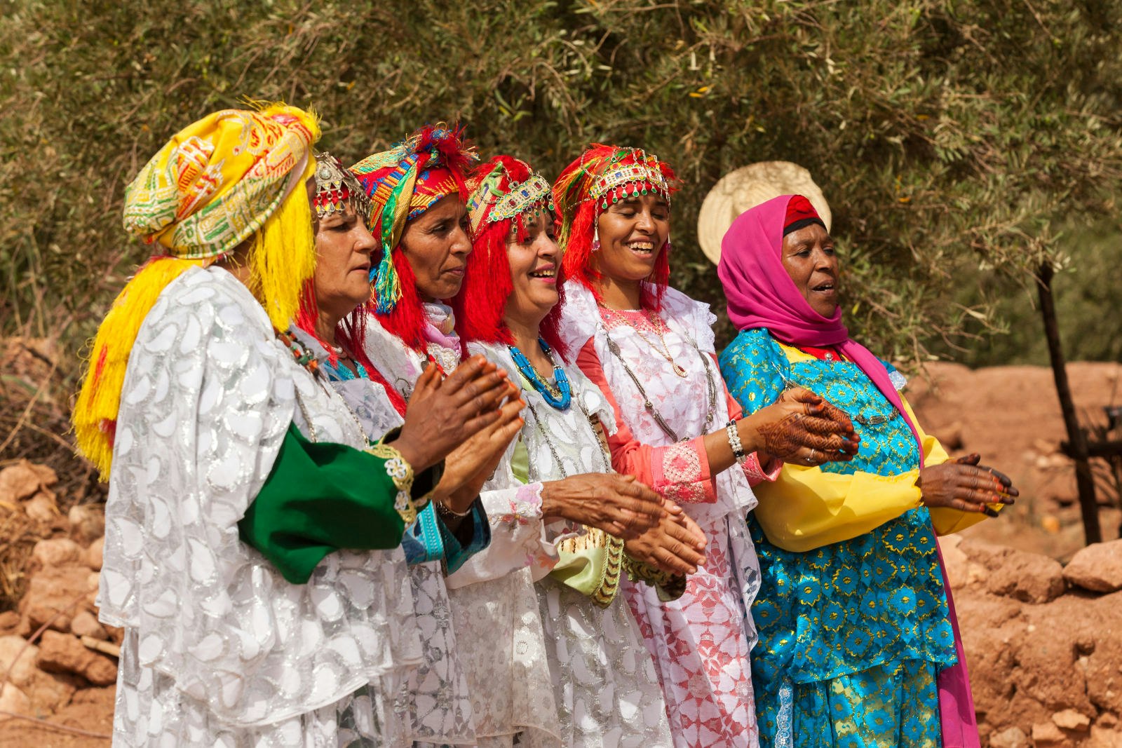 Six Berber women stand in a line at a wedding ceremony, dressed in colourful clothing