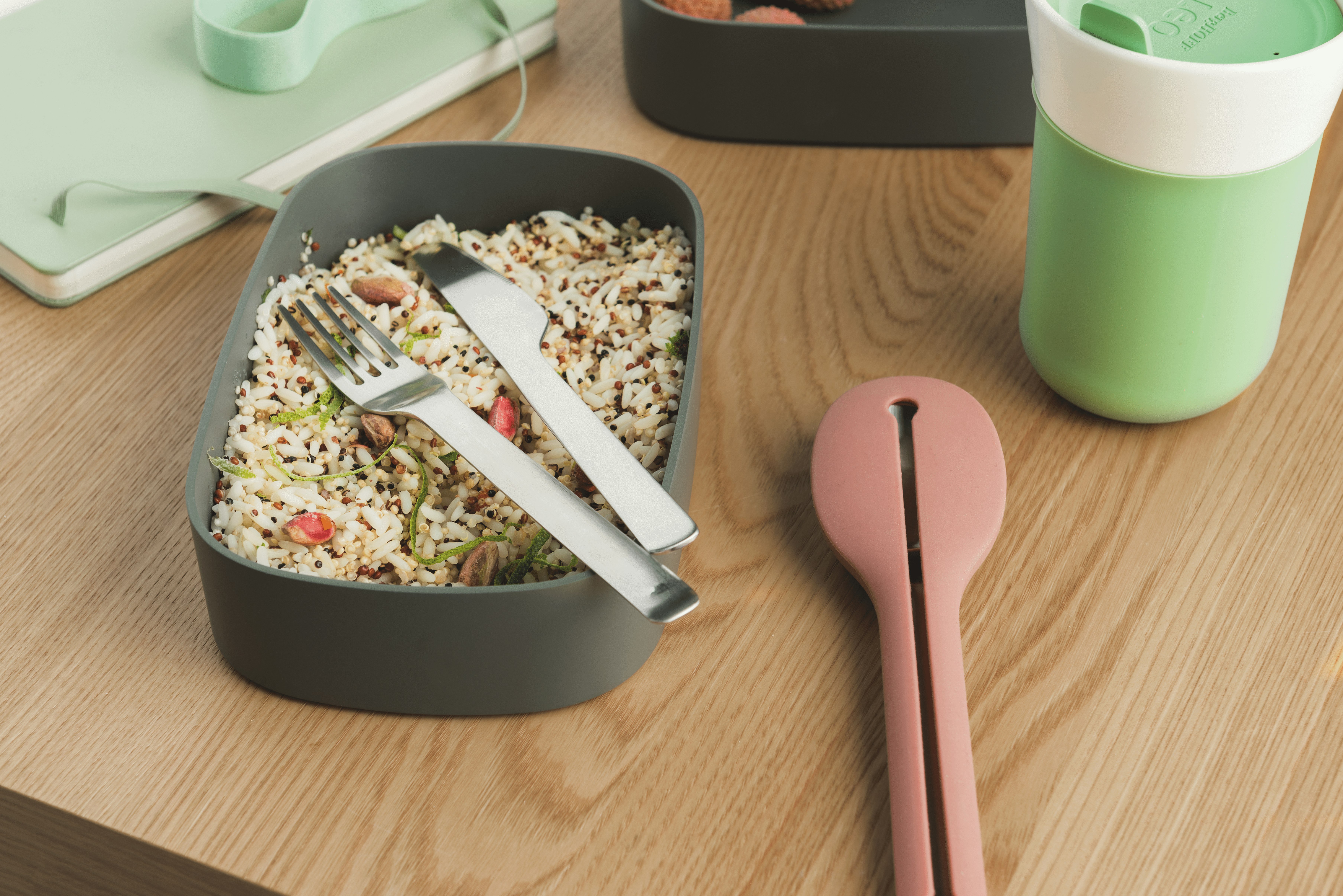 A reusable knife and fork set for eating a rice dish, with a carrying case nearby