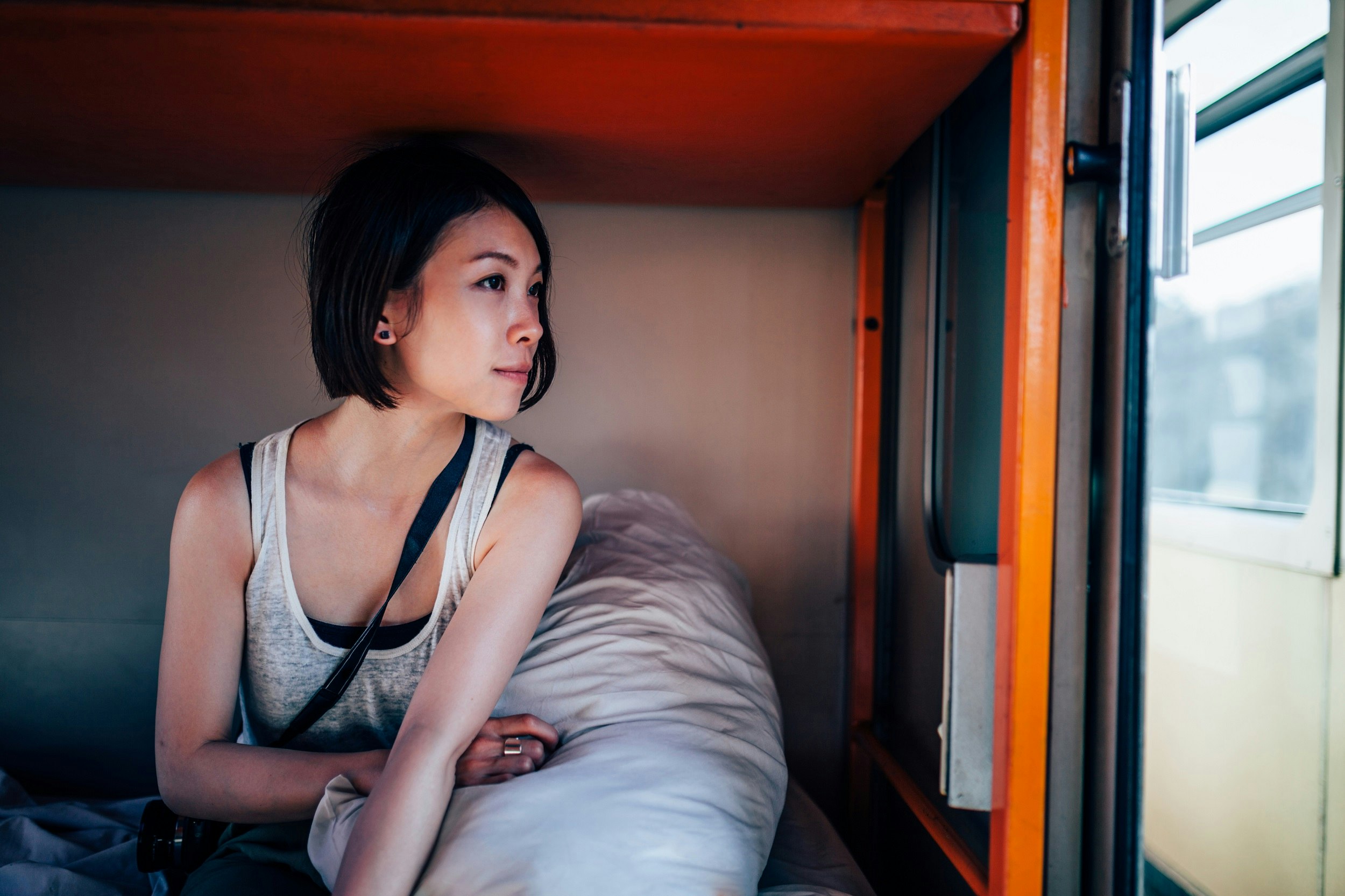 A woman sitting in bed on a sleeper train