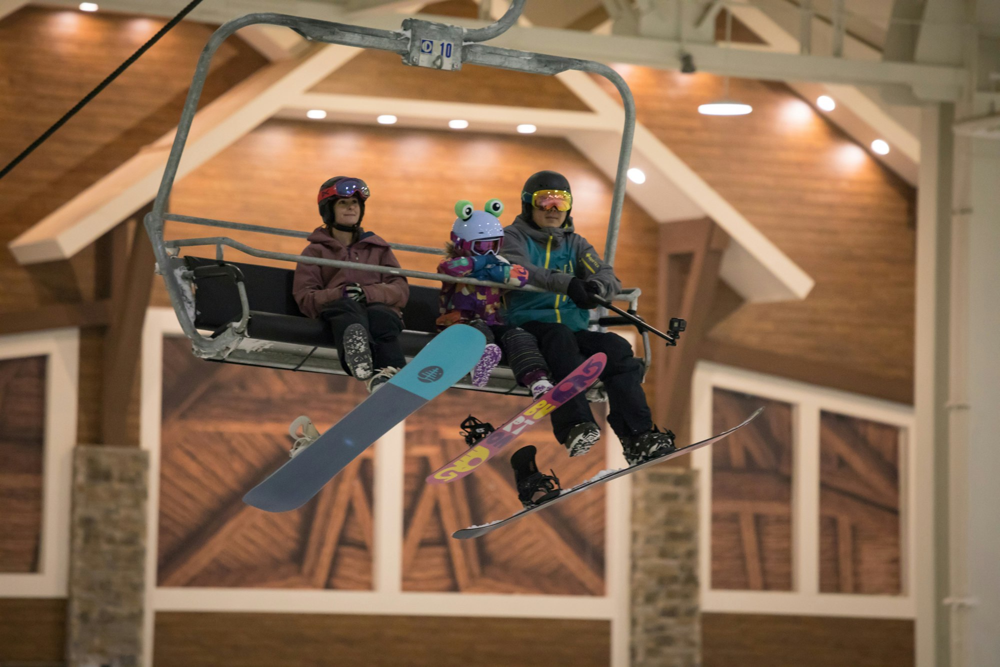 Three kids and their snowboards riding one of the lifts at Big SNOW