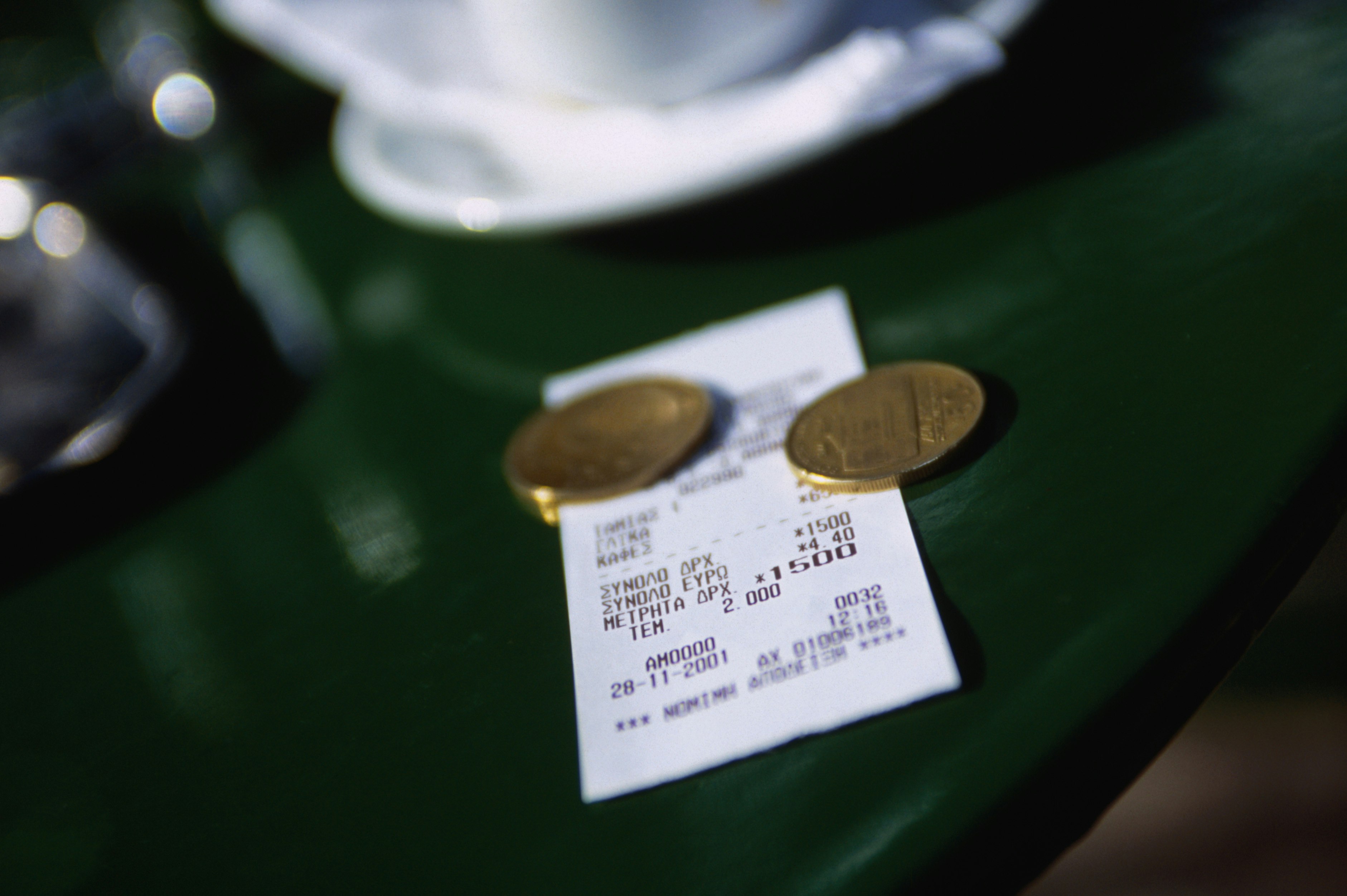 A bill and some coins on a small outside tables