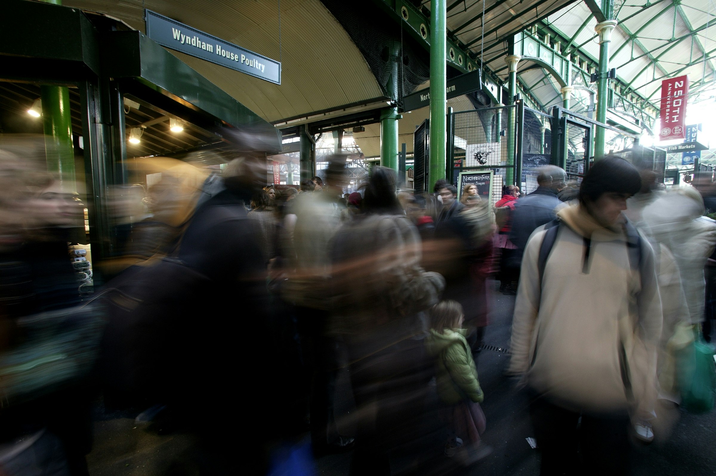 A blurred crowd moves through Borough Market in London