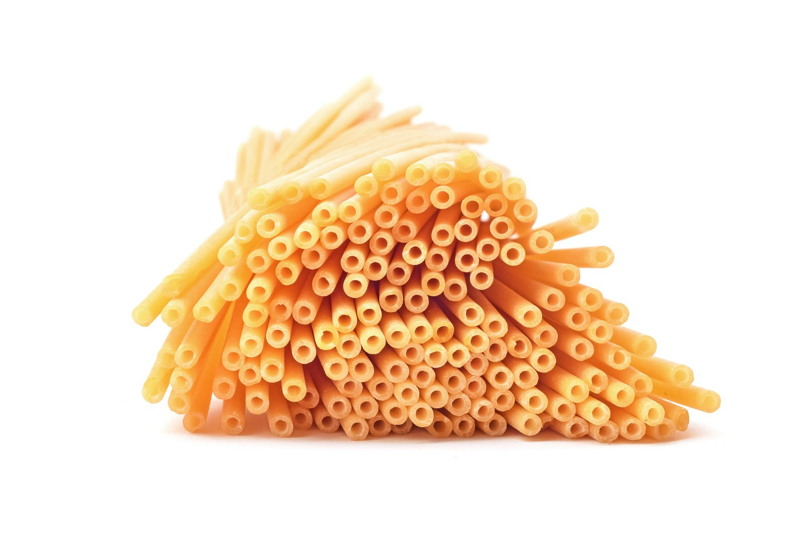 En bild av en näve bucatini-pastastrån mot en skarp vit bakgrund