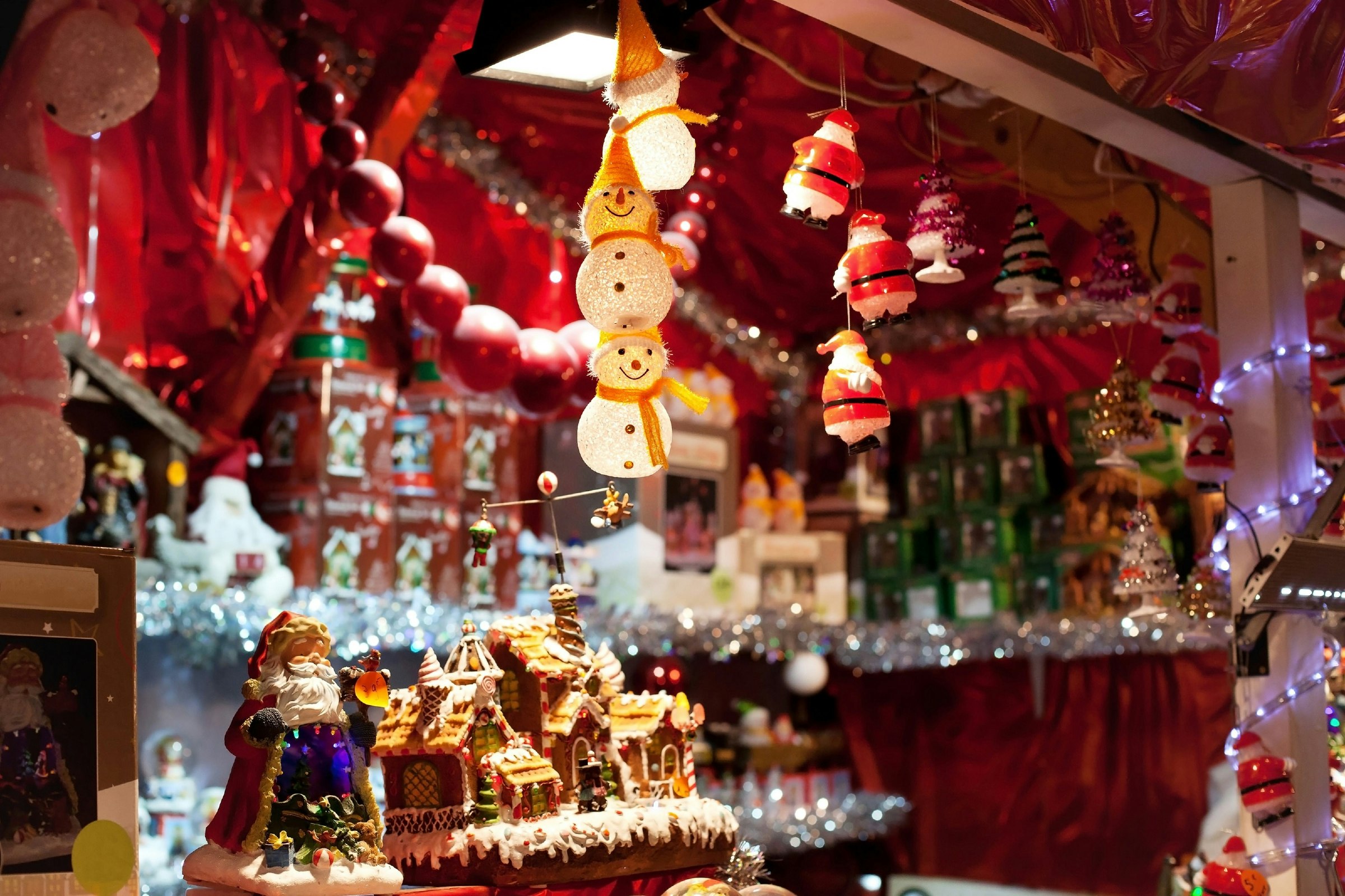 A stall of decorations, including a light-up snowman hanging from the roof and a manger.