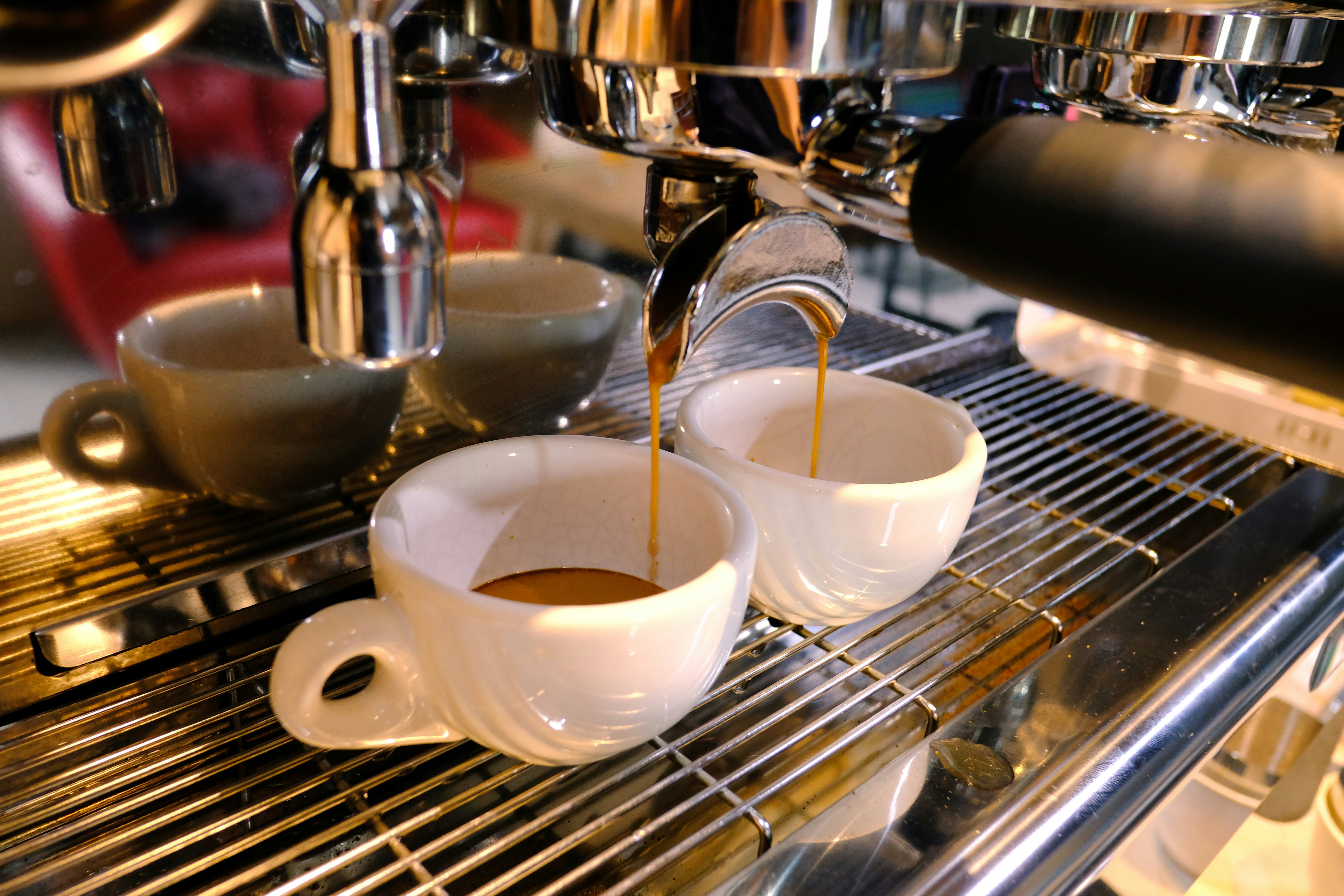 An espresso machine with two cups of cappuccino