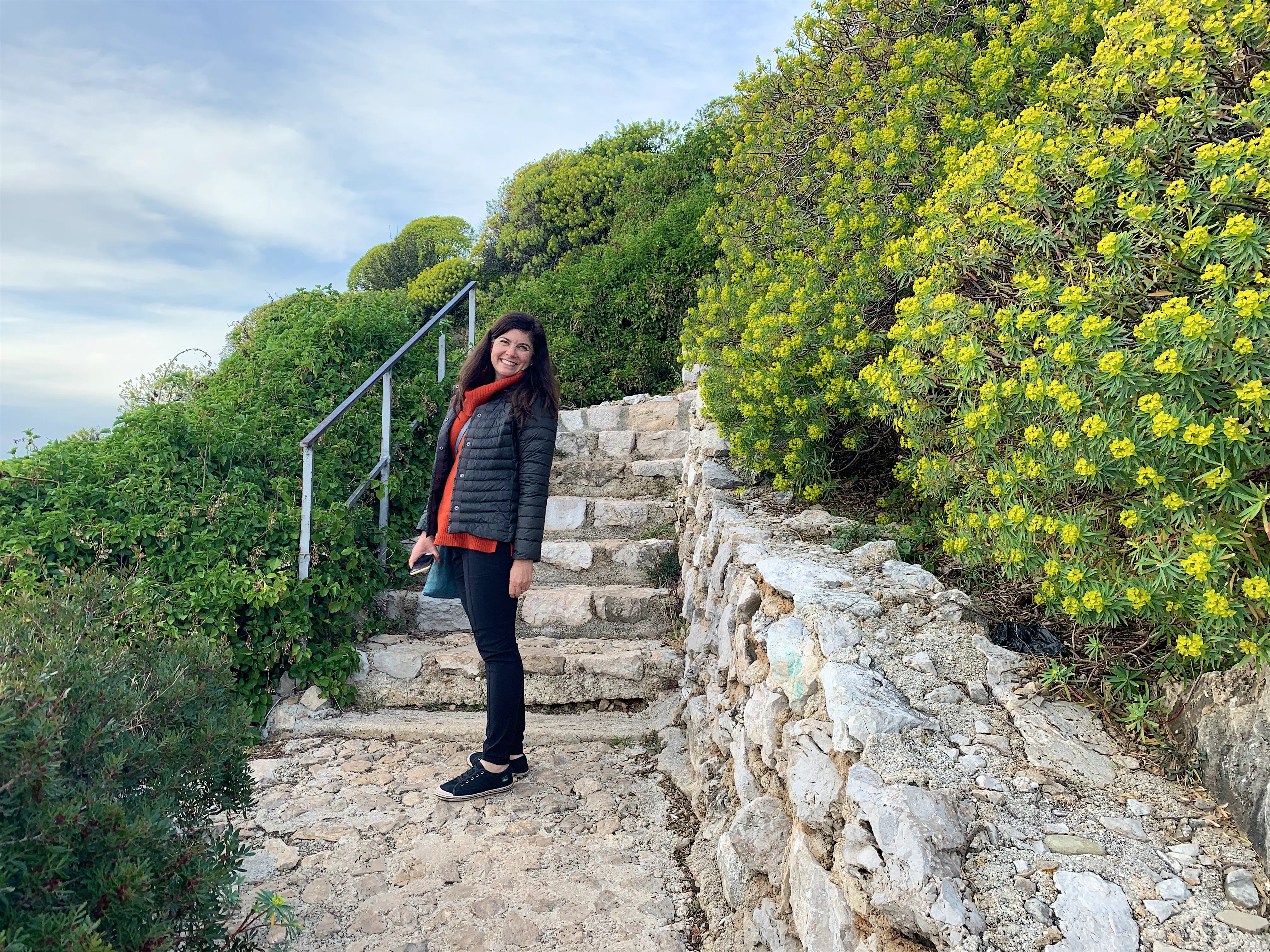 celeste brash france.jpg A woman stands on stairs next to flowers