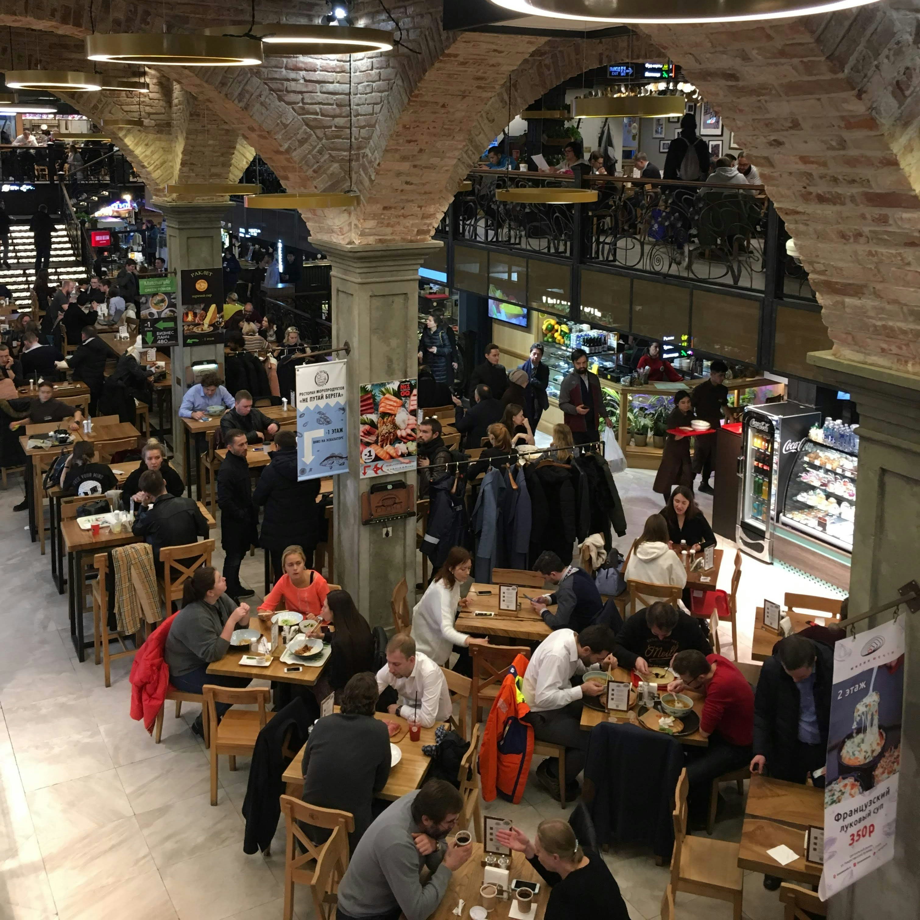 A view from above of diners seated at tables in a food market