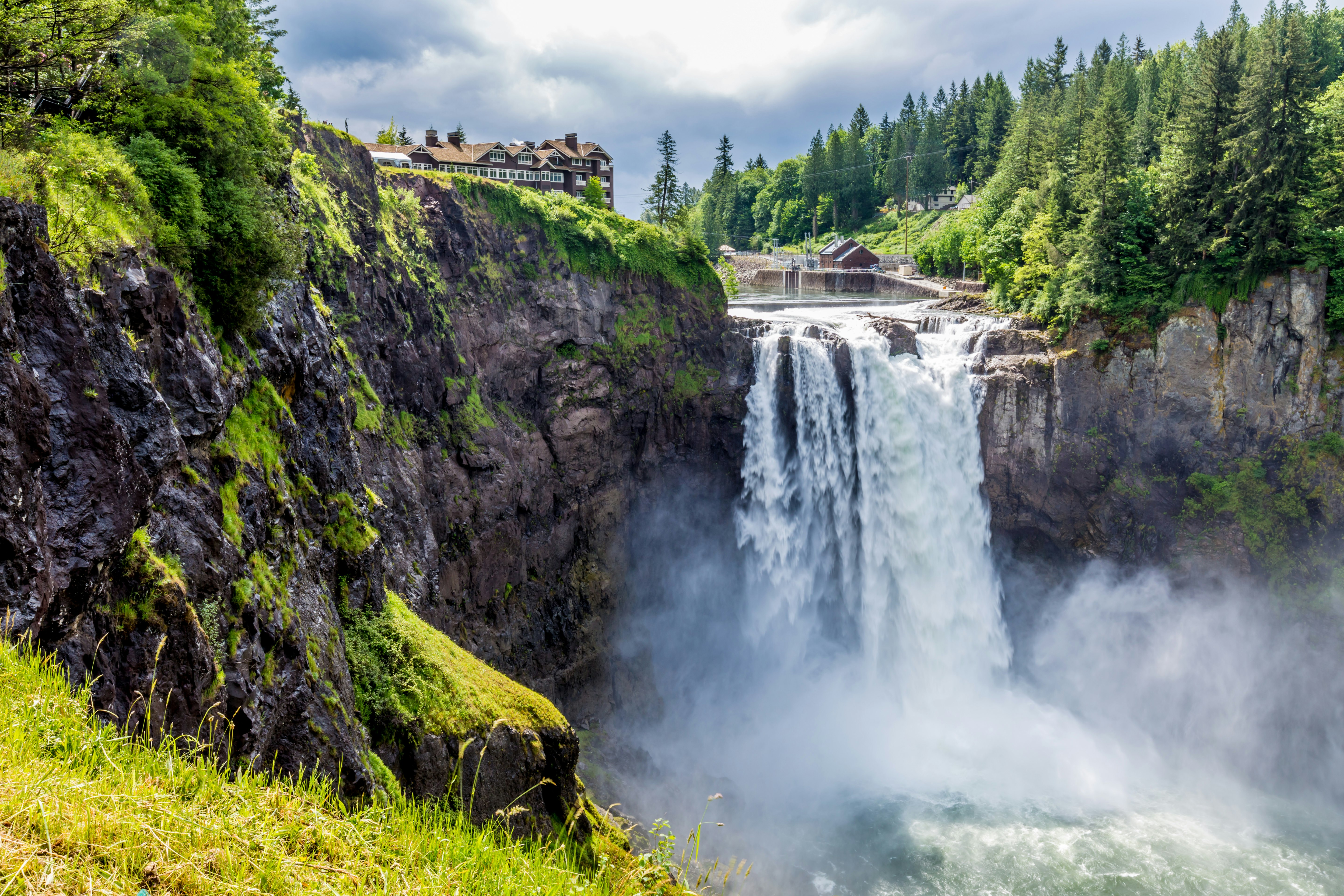 A waterfall rushes with a lush green background. 