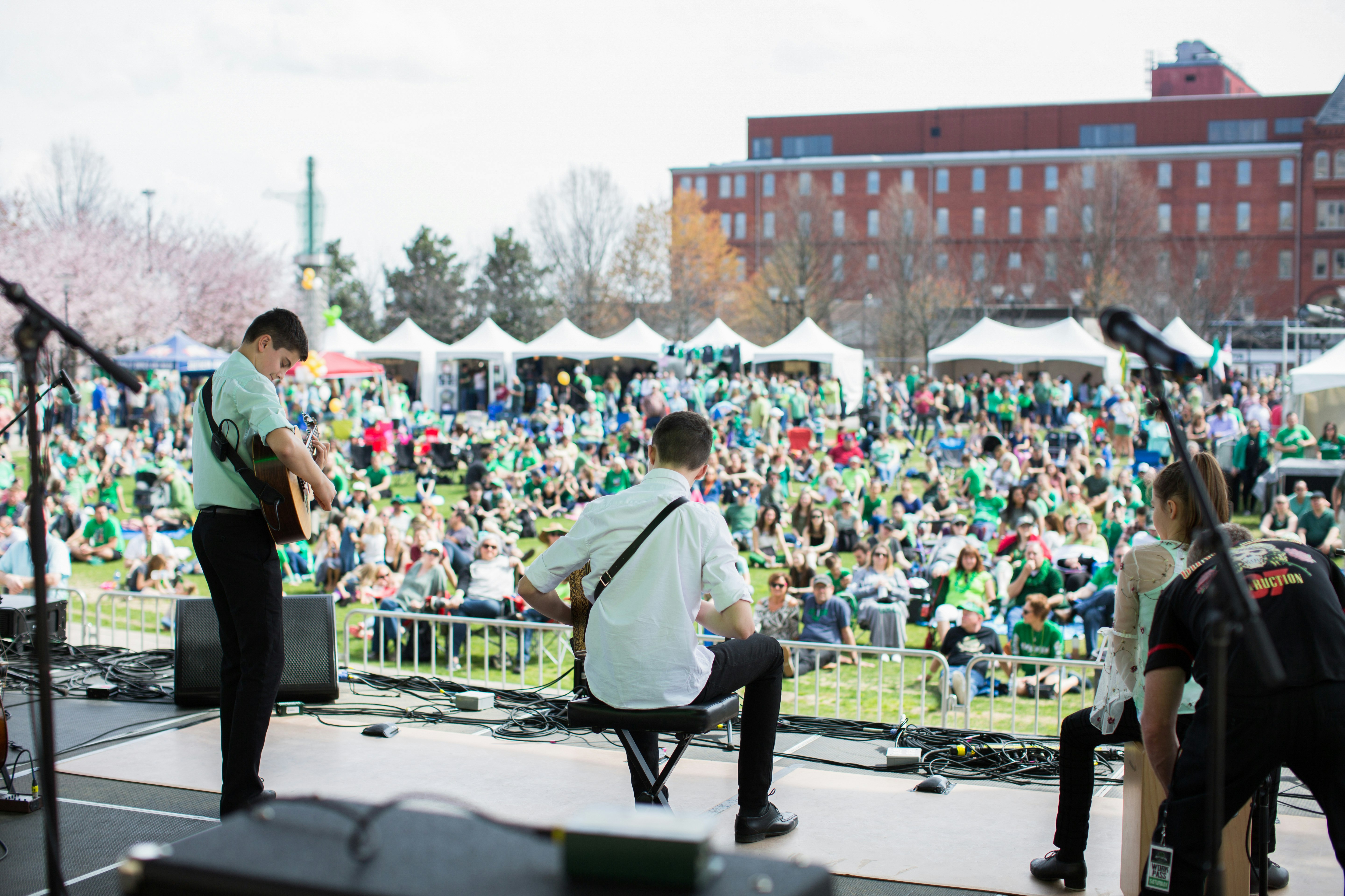 Traditional Irish musicians perform to a crowd at an open-air venue