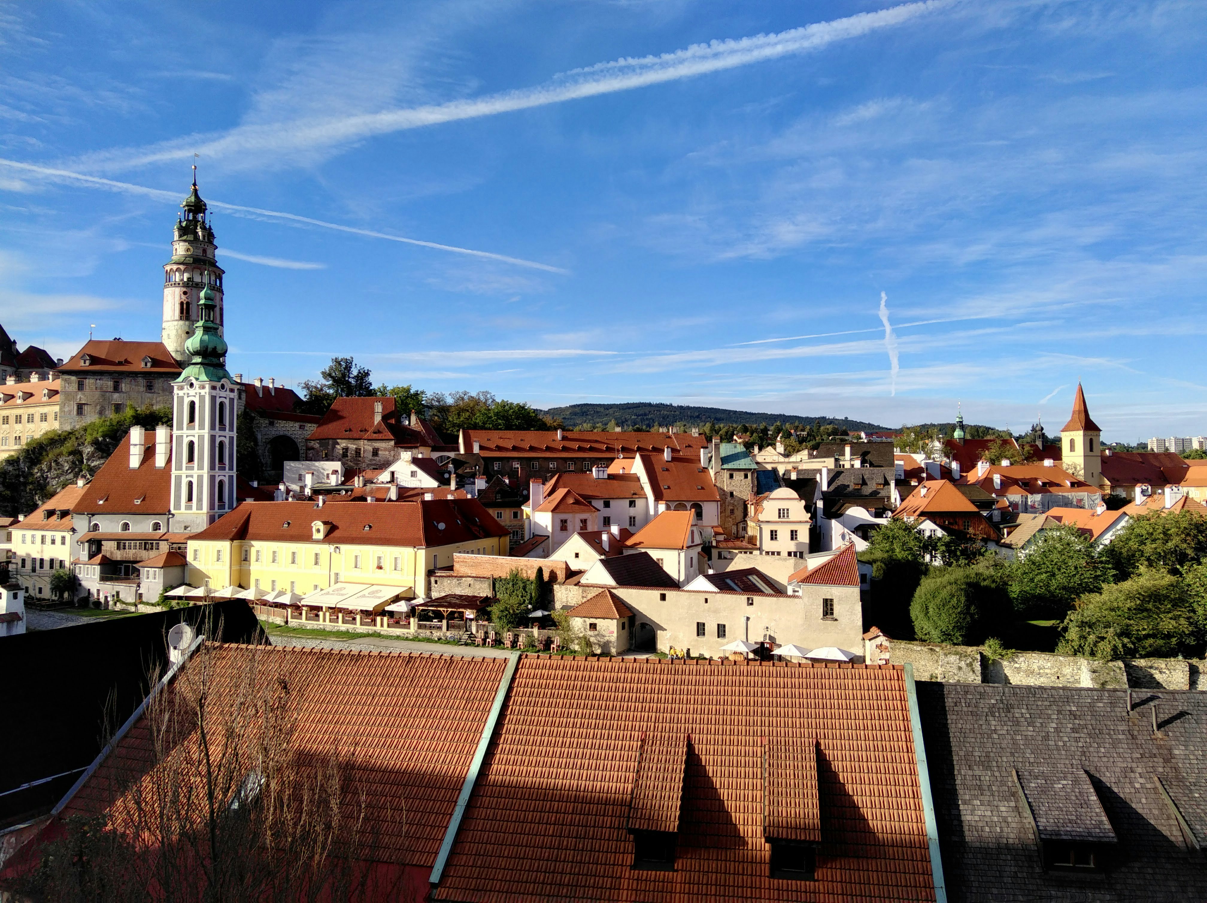 A view over the red-tiled rooftops of Český Krumlov on a sunny day.